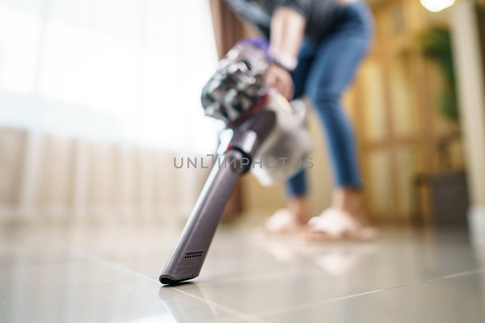 Woman use vacuum cleaner cleaning on floor.