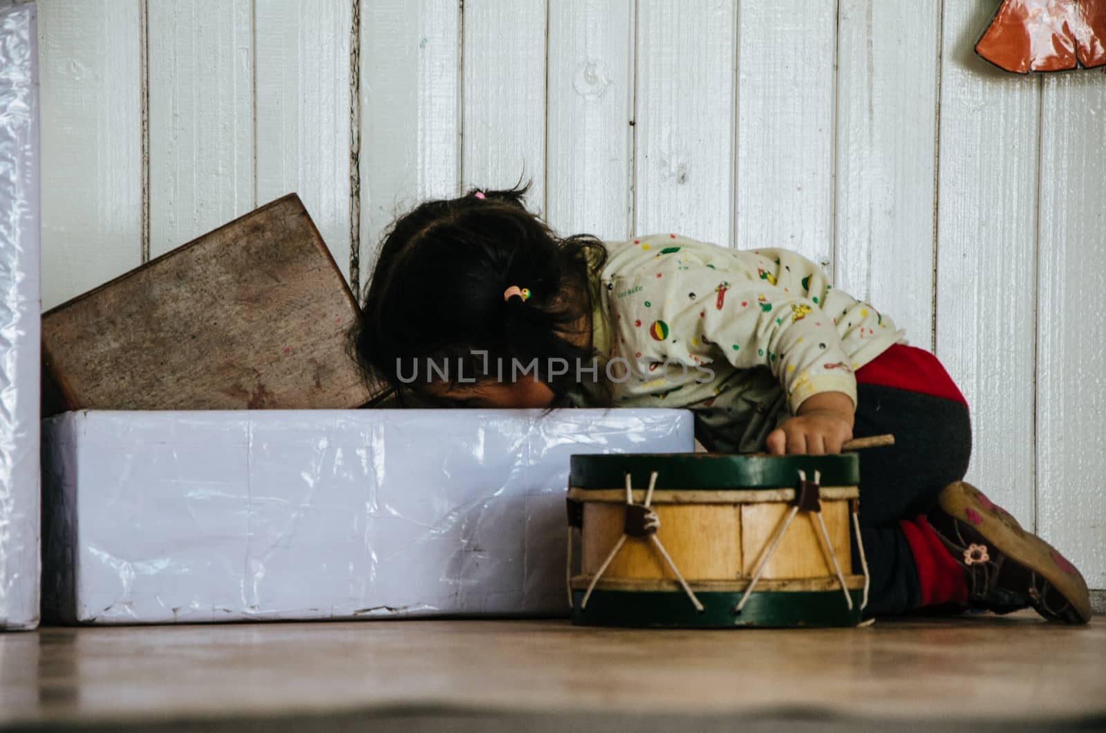 Little girl playing and looking for toys in a box