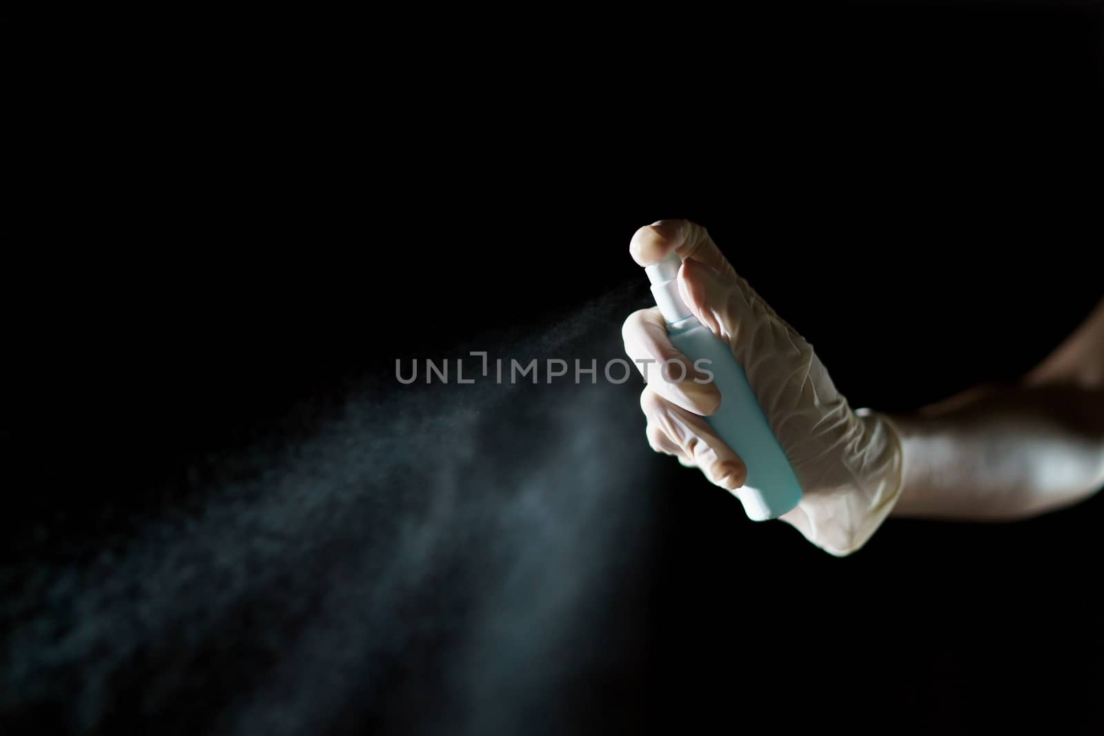 Hand using sanitizer spray, alcohol spraying disinfectant to stop spreading coronavirus or COVID-19.