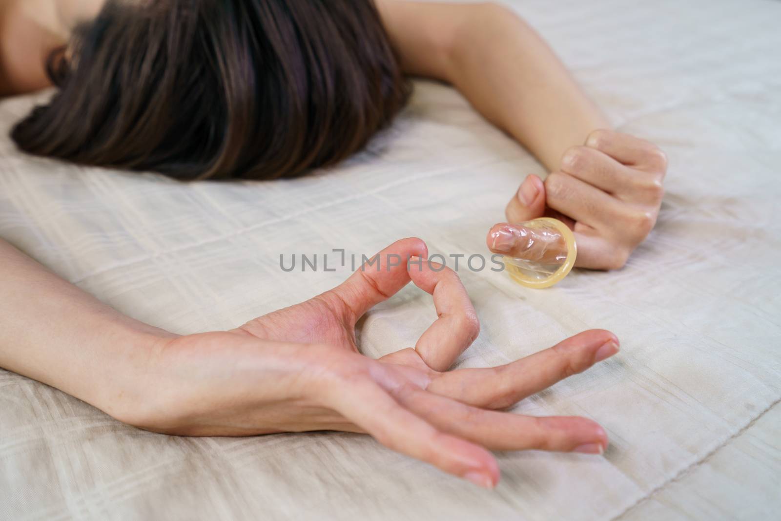 The sex hand sign. women's hands gesture indicating sex and putting condom on her fingers.