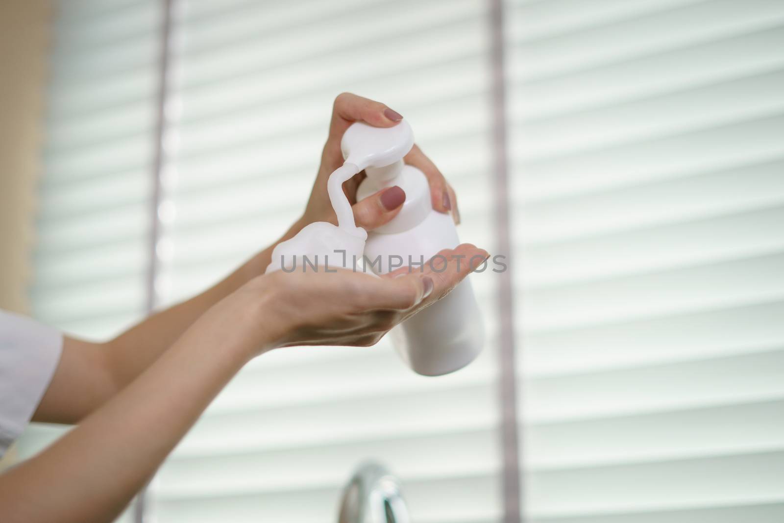 Woman hands pump liquid soap into palm for washing hands. For killing germs, bacteria and virus.