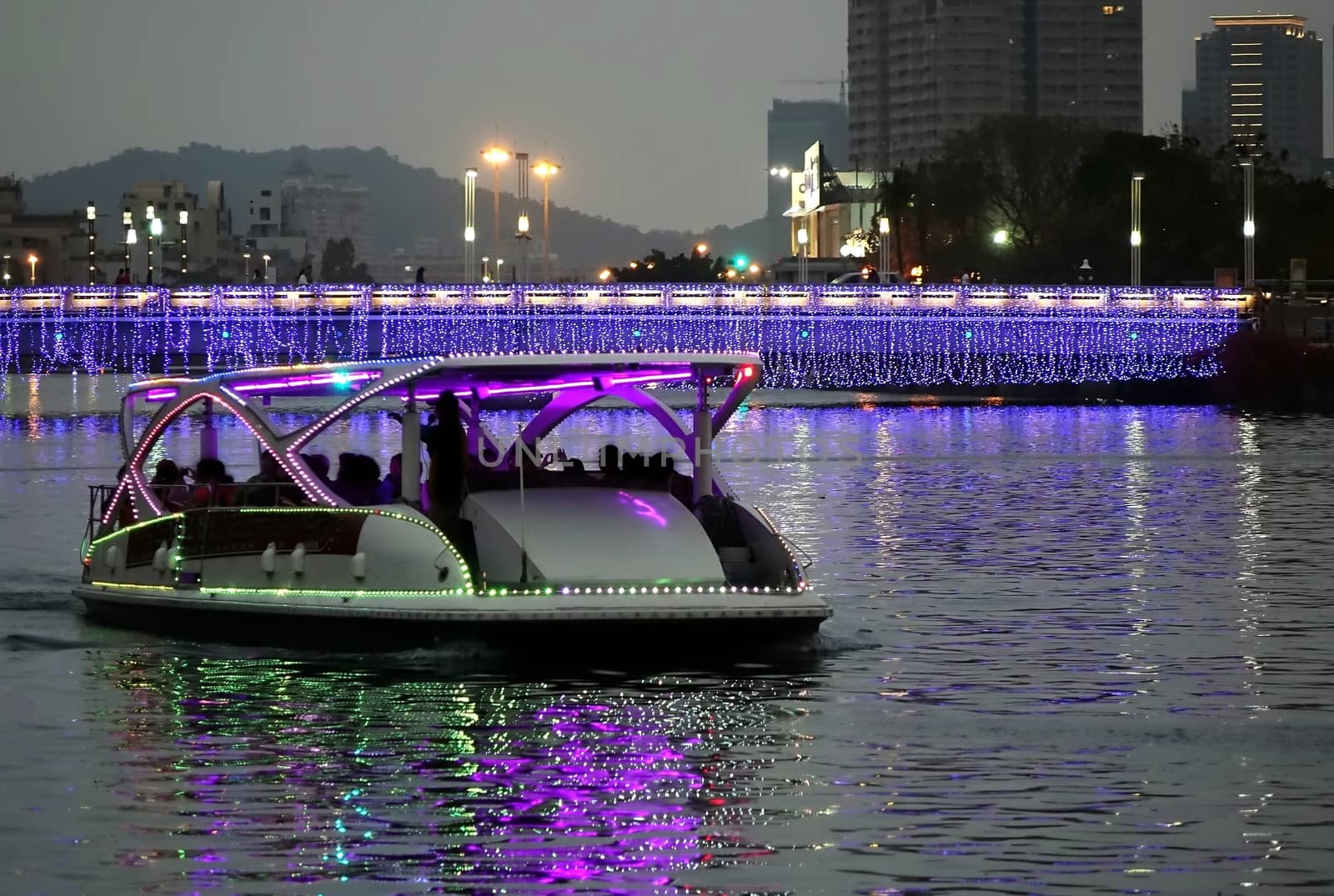 A solar powered boat transports travellers along the Love River in Kaohsiung, Taiwan at dusk.

