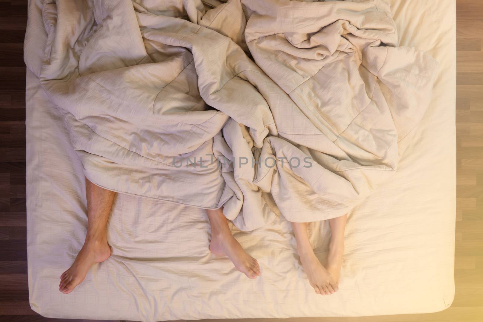 Close up of male and female feet sleeping on a bed in the bedroom.