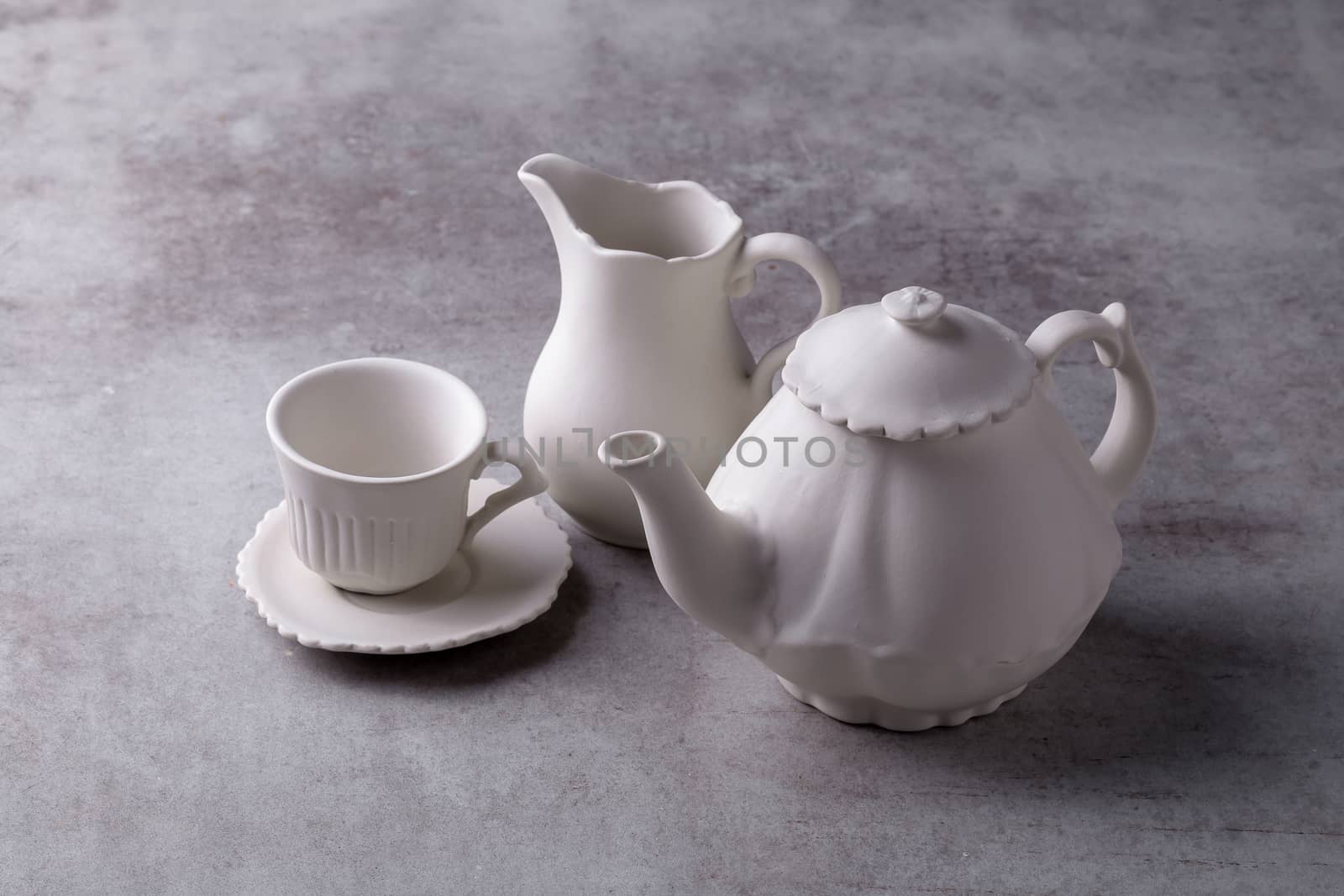 Teapot creamer, Cup and saucer on Cement Board.