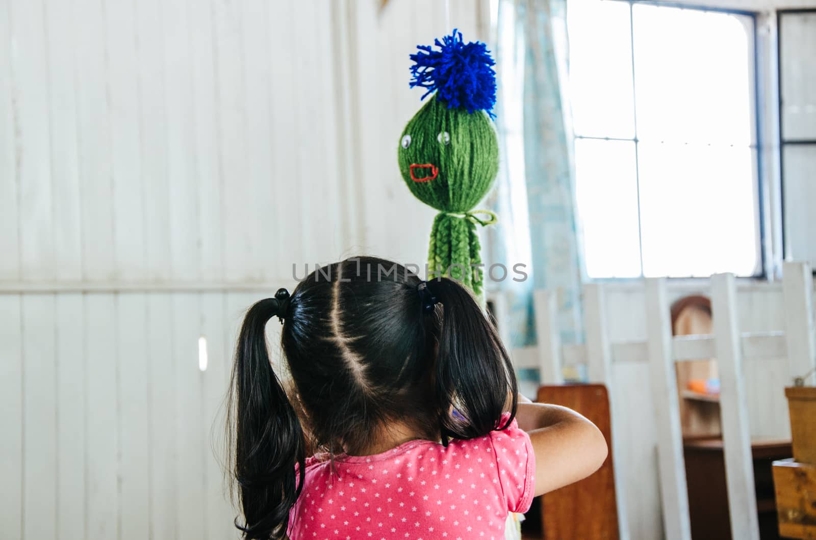 A little girl playing with a toy that has the shape of an octopus