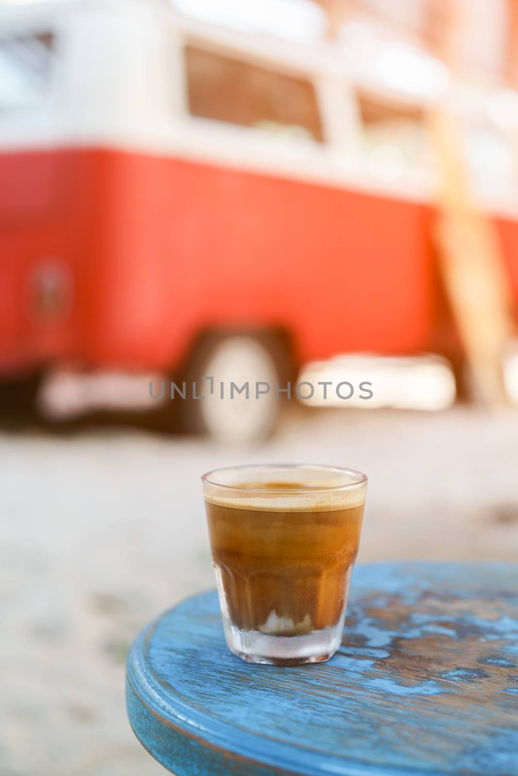 Dirty Coffee : glass of espresso shot mixed with cold fresh milk on blurred beach background.