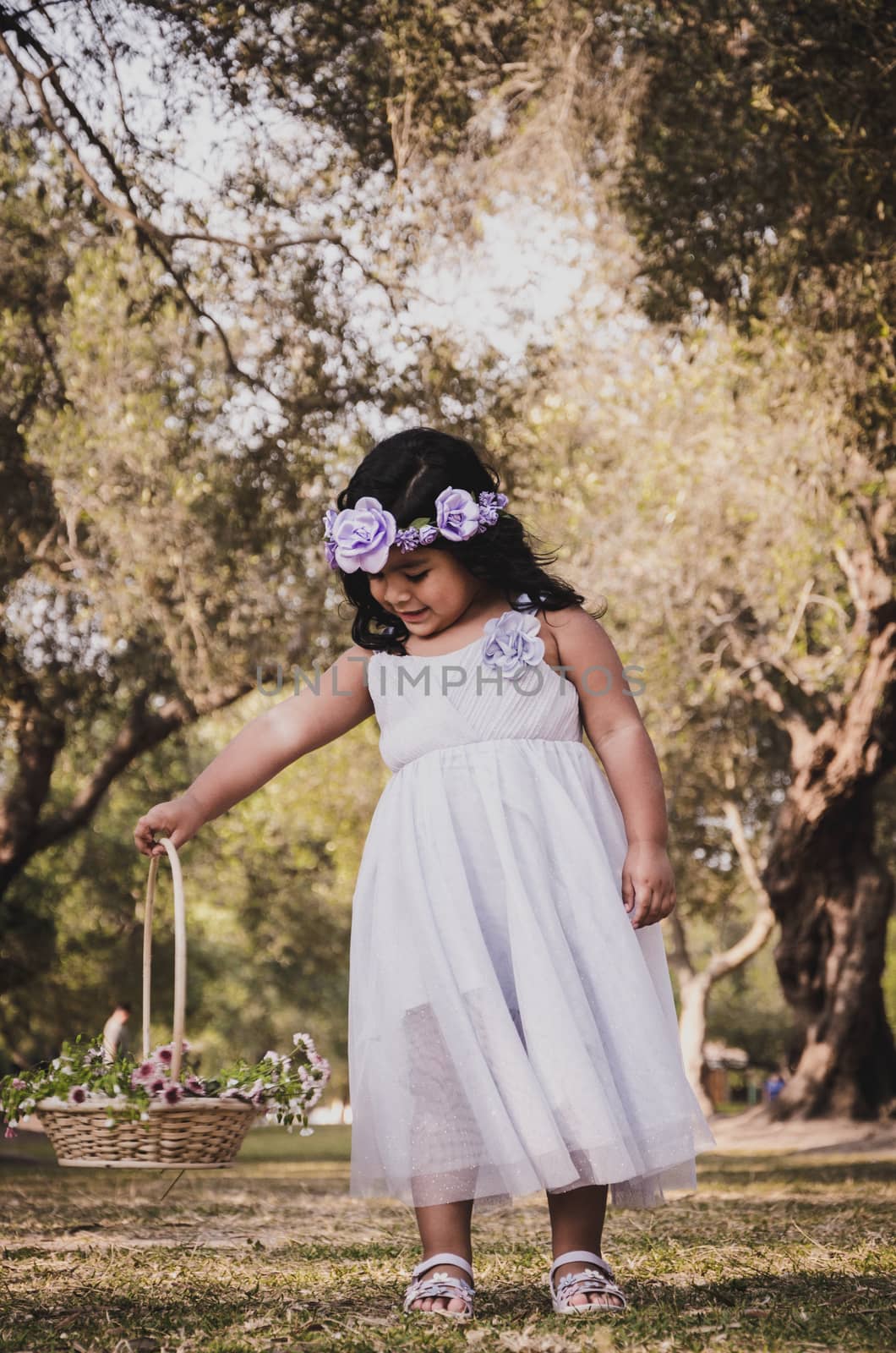 Little girl with a basket of flowers smiling