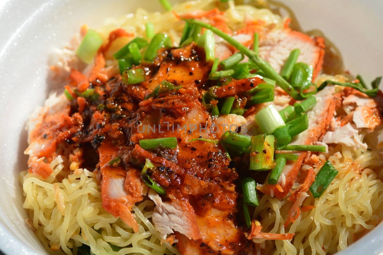 The close up of crab meat on the dried Chinese egg noodle with roasted red pork.