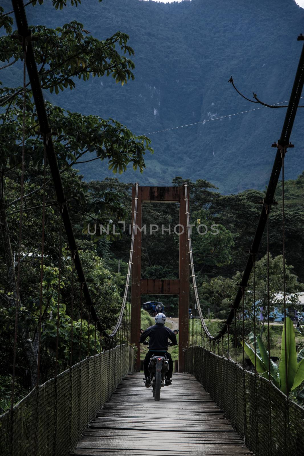 Motorcycle crossing the La Cañera pedestrian bridge located in Oxapampa - Peru