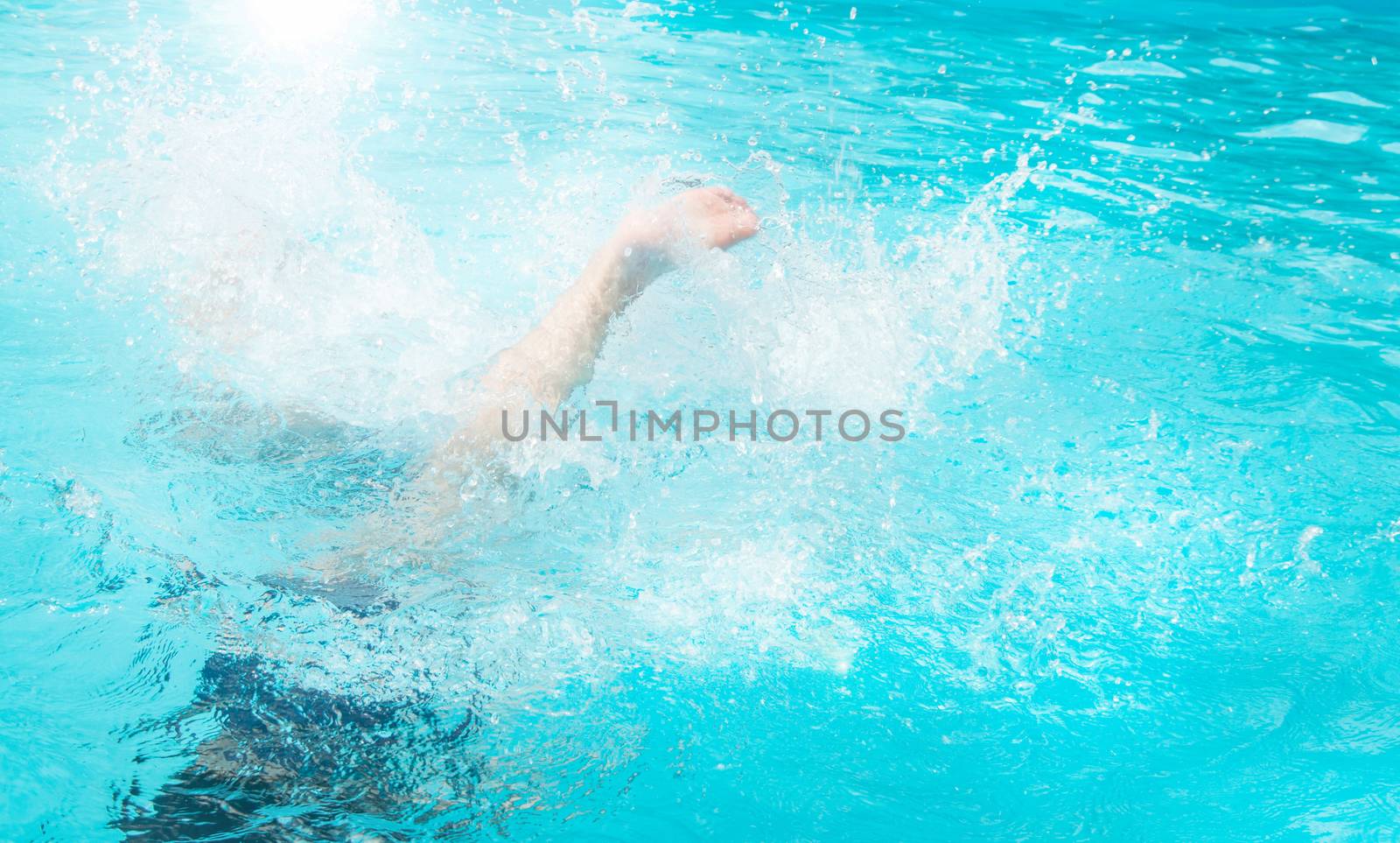 Children teenagers girls have fun swimming and diving in the outdoor pool, feet up over the water, splashing, sunlight, glare, summer day by claire_lucia