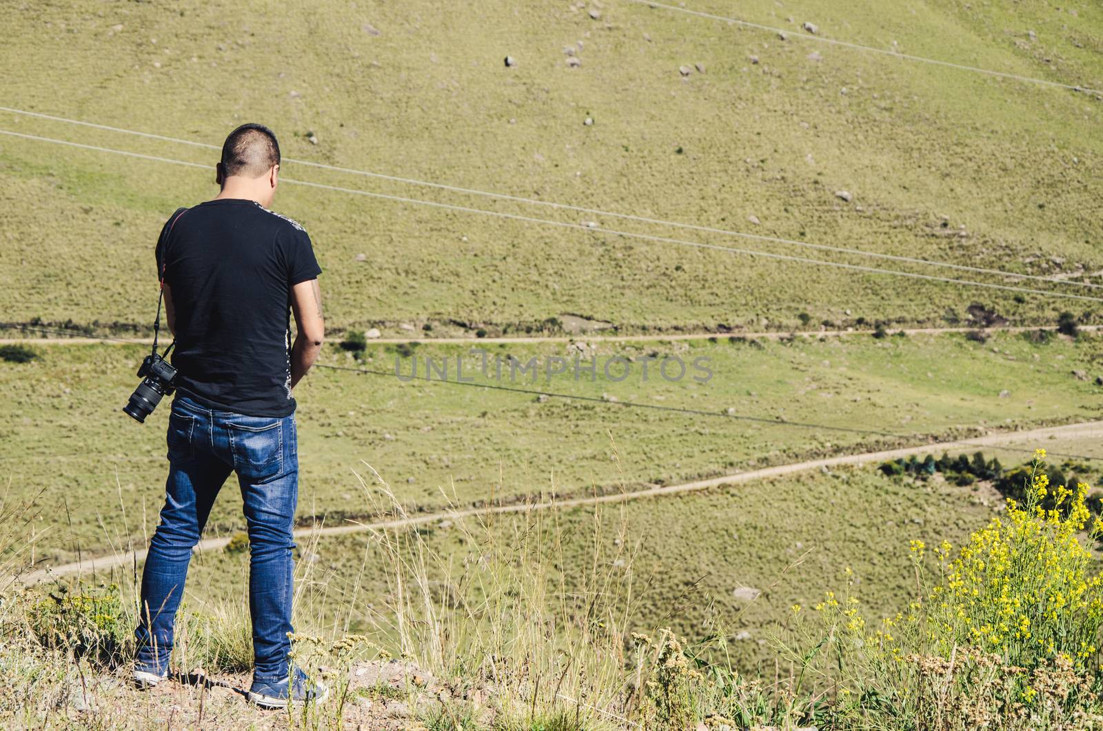 Man with photo camera peeing through the bushes