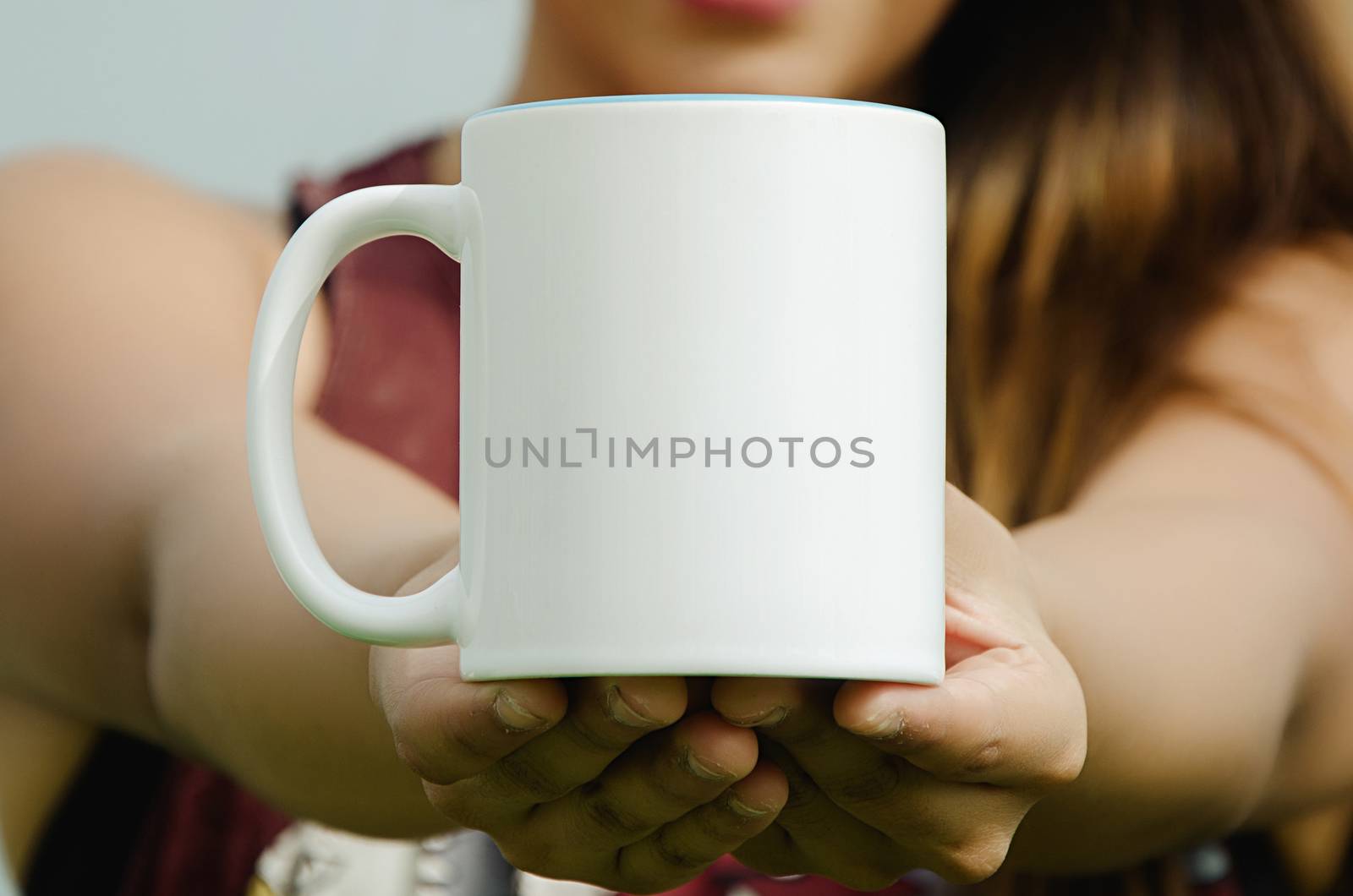 Blank cup in hand of a girl smiling
