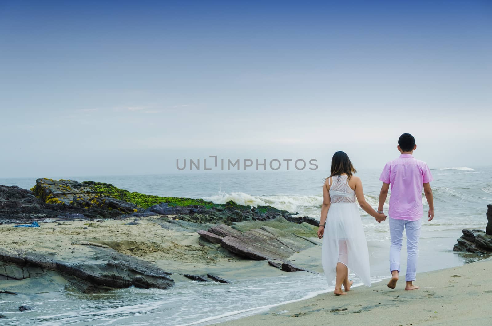 A couple in love walking at the edge of the sea