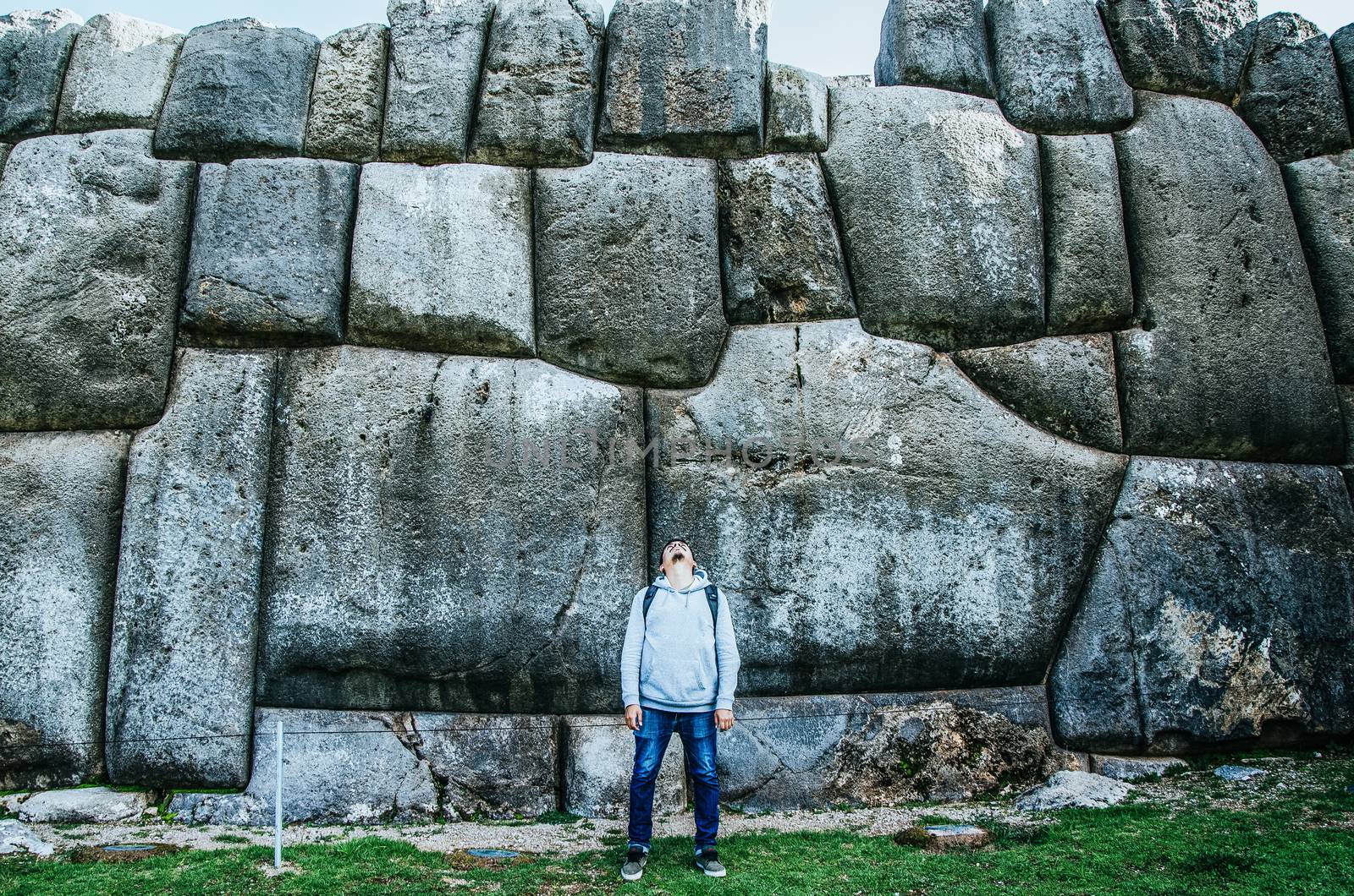 Man posing in front of the huge rocks of Sacsayhuaman in Cusco - Peru