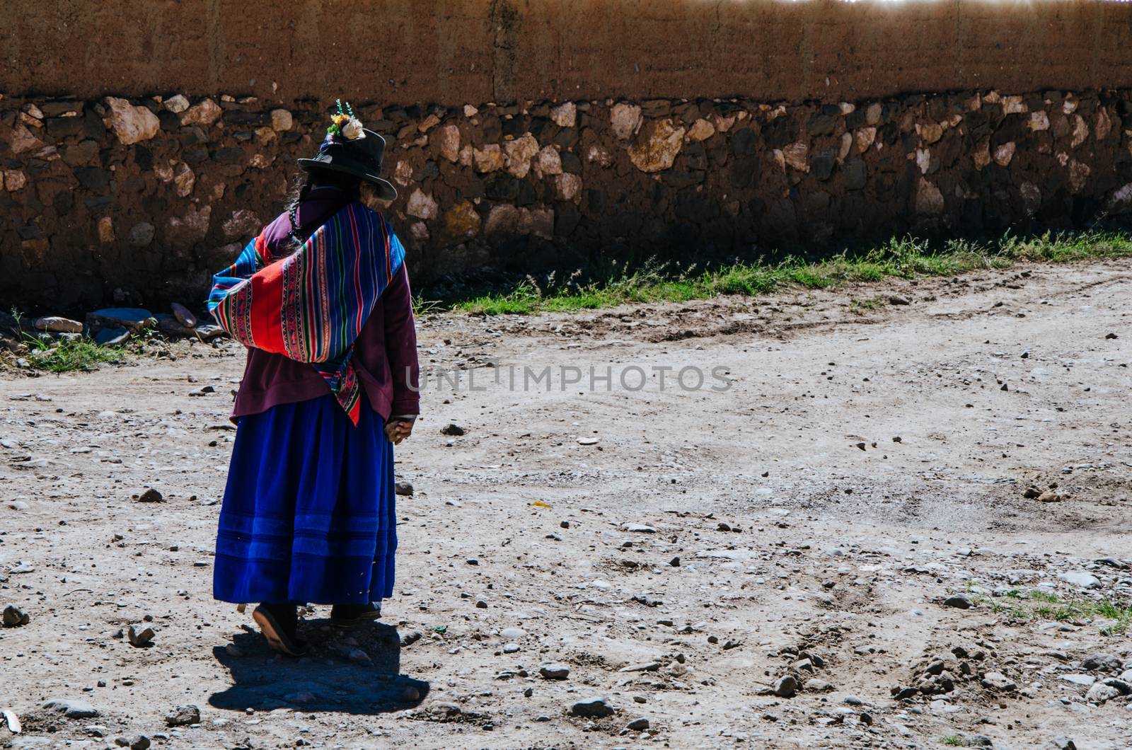 Elderly woman of the Andes walking on the ground