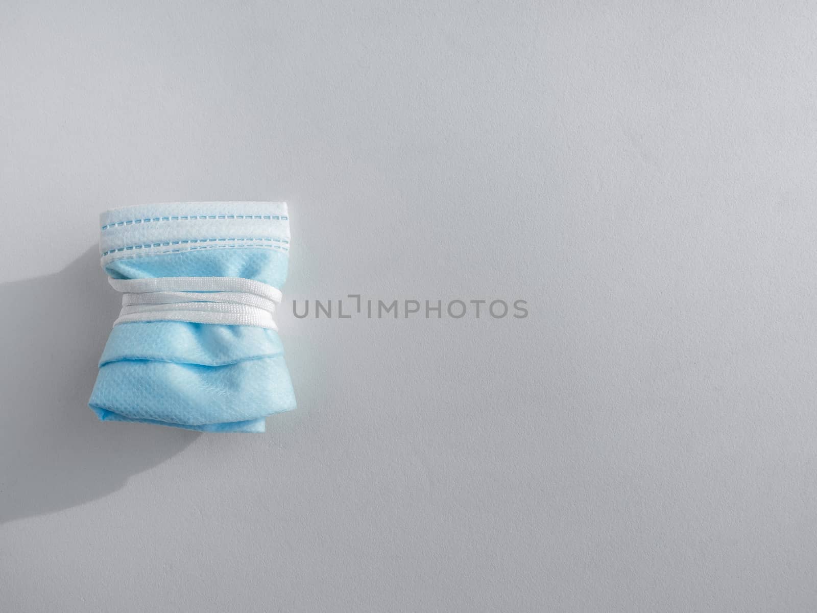 Used mask concept. Folded used protective face mask isolated on white background with copy space. Protection before littering for prevent spread of virus.