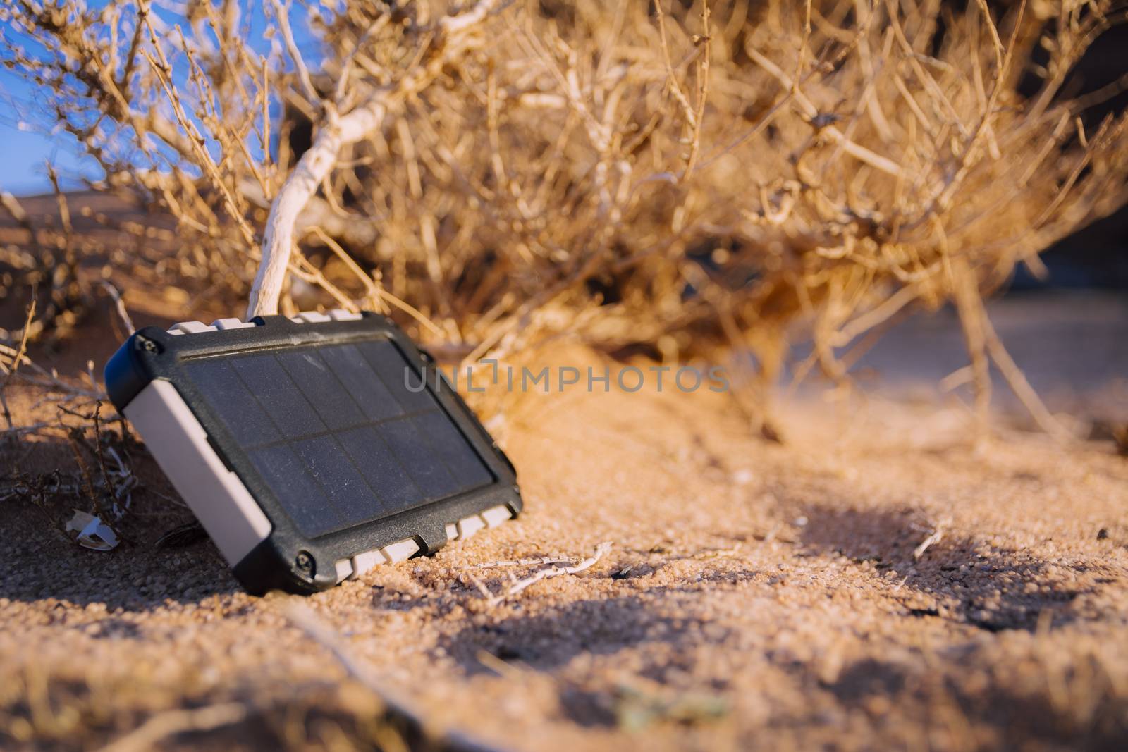 Rugged power bank with solar panel charging electricity in the desert by kb79