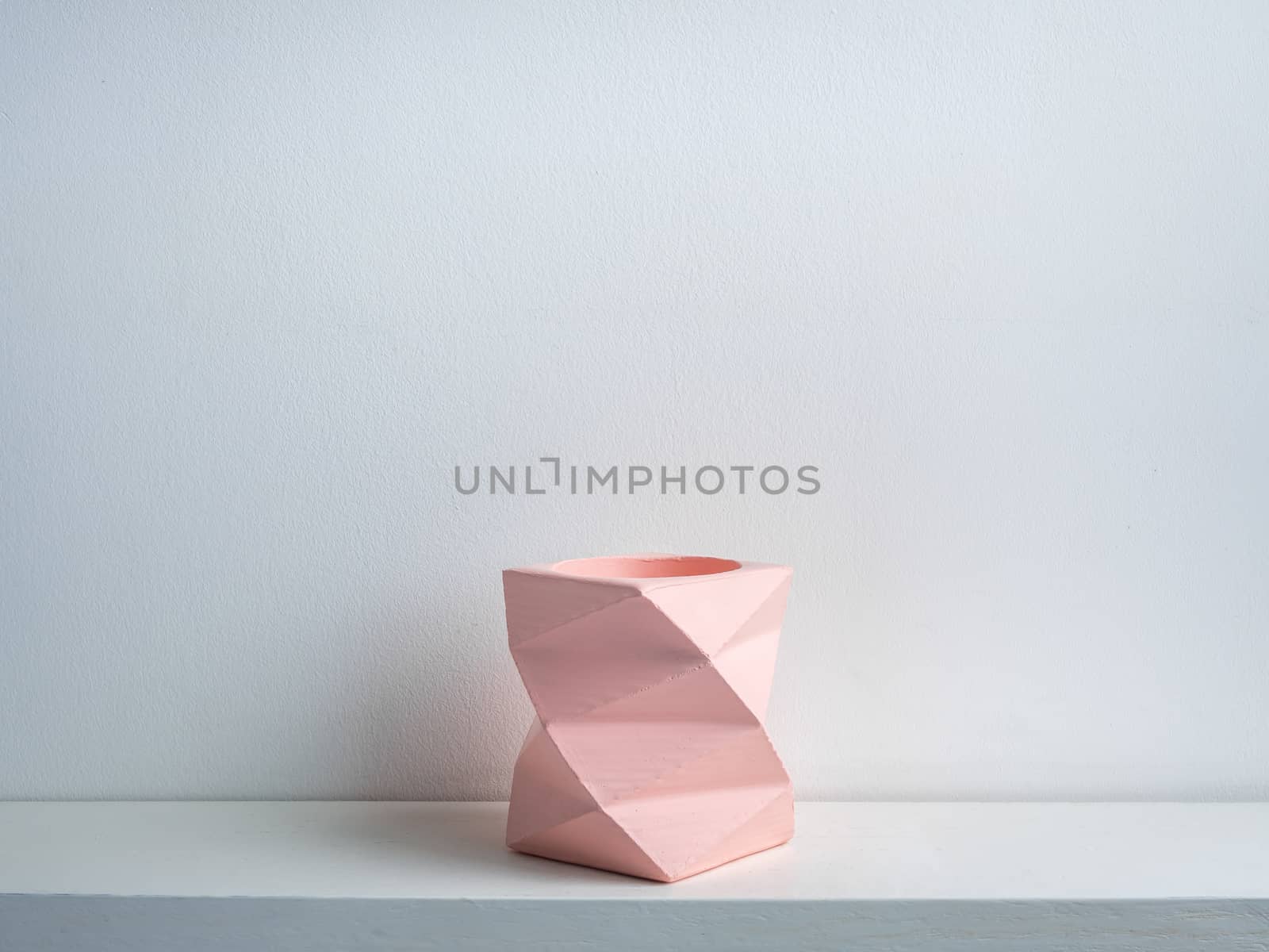 Cactus pot. Concrete pot. Empty pink modern geometric concrete planter on white wooden shelf isolated on white background.