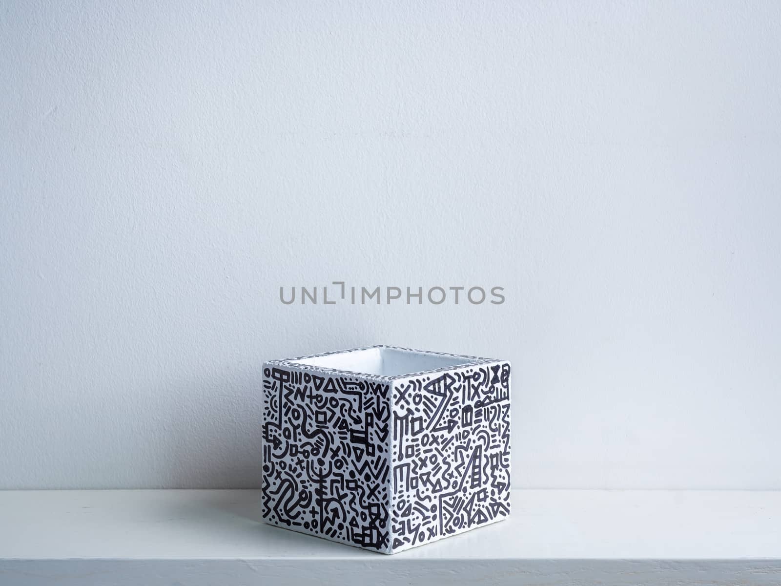 Cactus pot. Concrete pot. Empty white with modern graphic pattern geometric concrete planter on white wooden shelf isolated on white wall background.