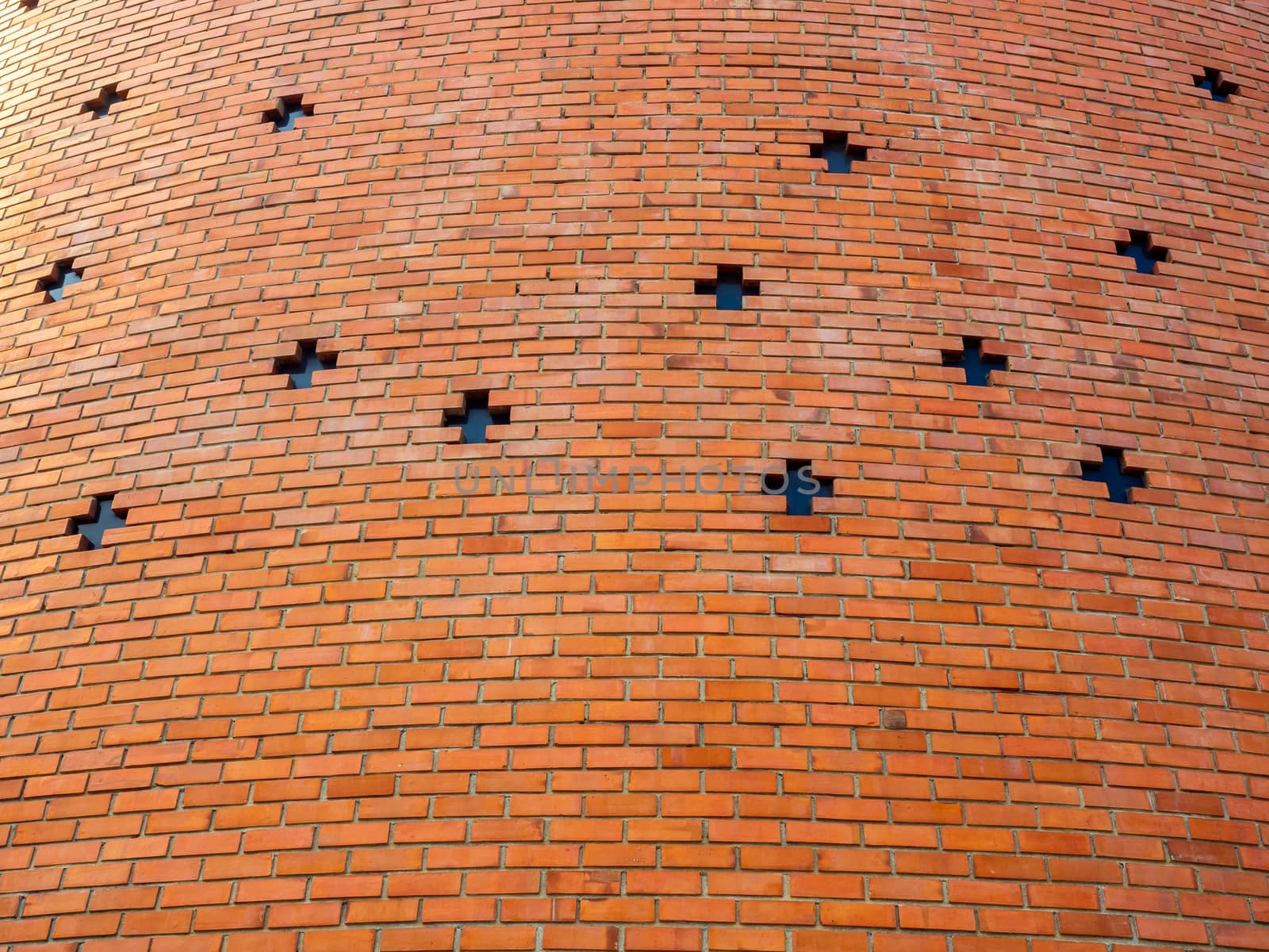 Red brick wall background with cross shaped window. Seamless brick wall texture building.