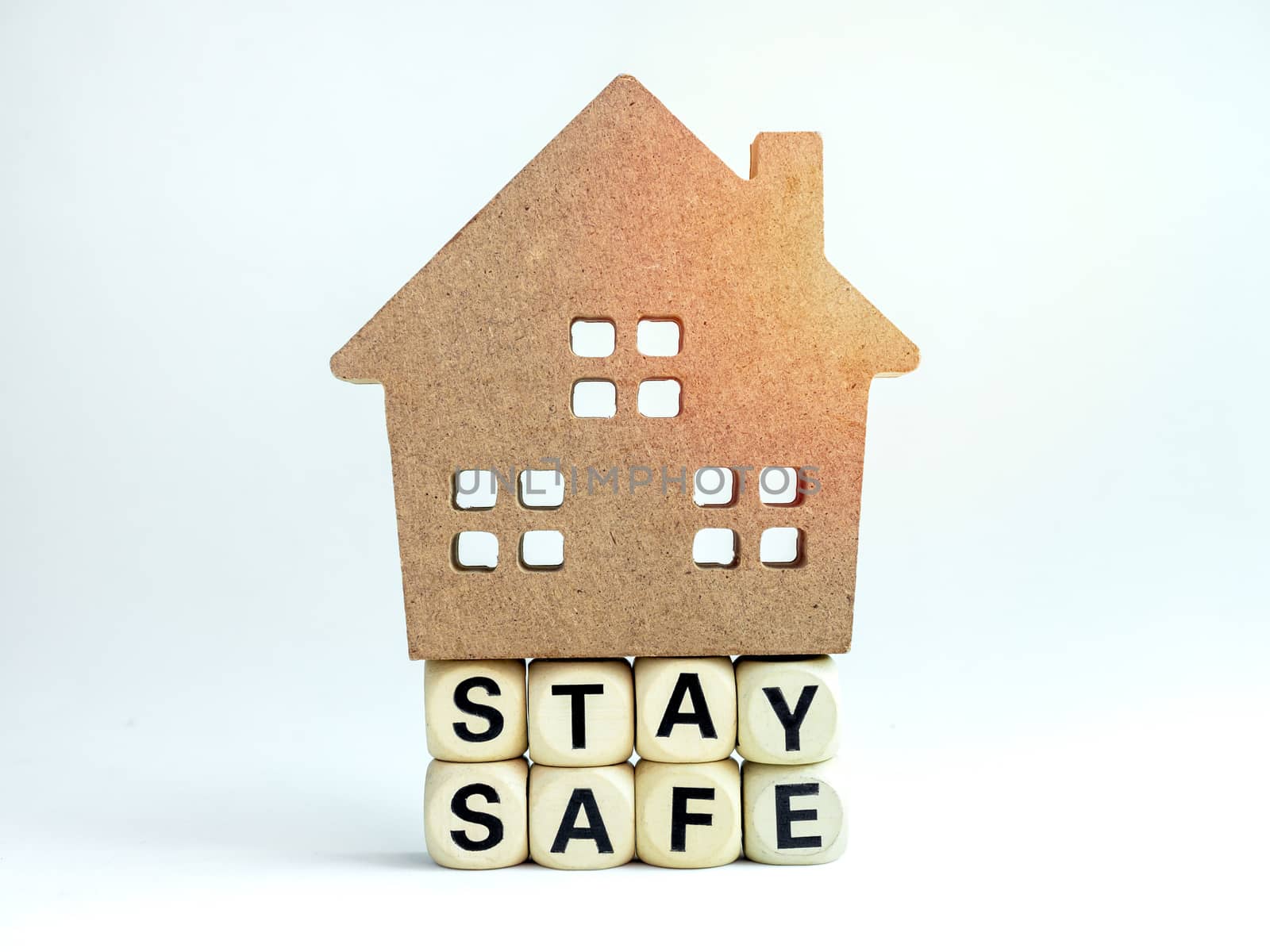 Stay safe concept. Word "Stay Safe" with wooden house isolated on white background, stay at home, social media campaign for covid-19 or coronavirus pandemic prevention.
