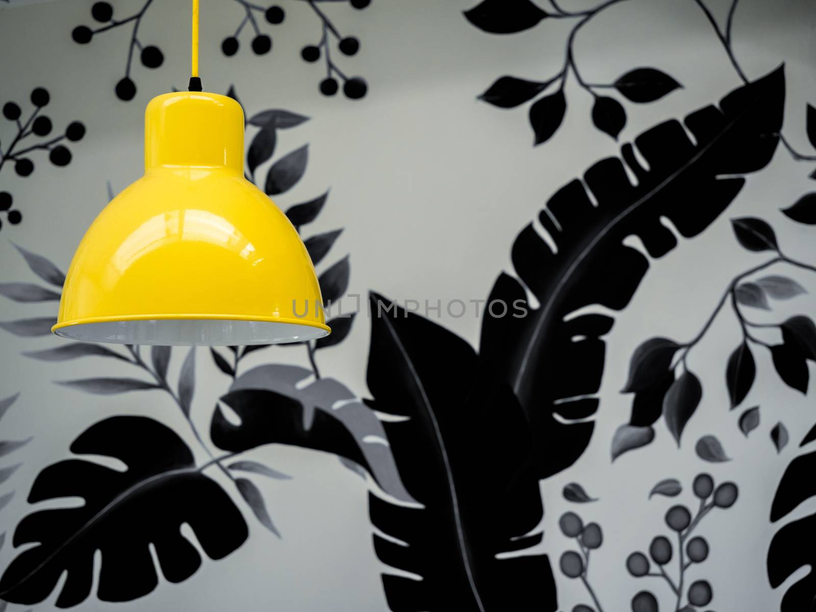 Modern yellow ceiling light on wallpaper, tropical palm leaves in black and white colors background with copy space.