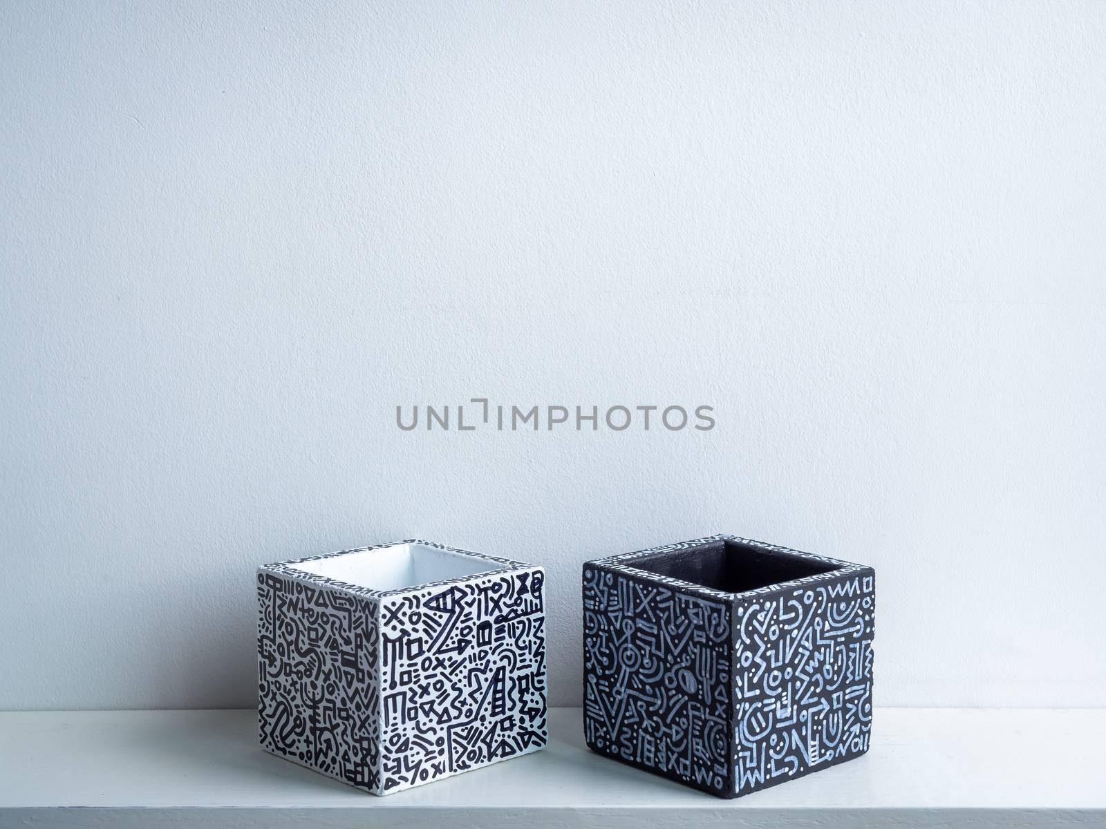 Cactus pot. Concrete pot. Empty black and white with modern graphic pattern geometric concrete planters on white wooden shelf isolated on white wall background.