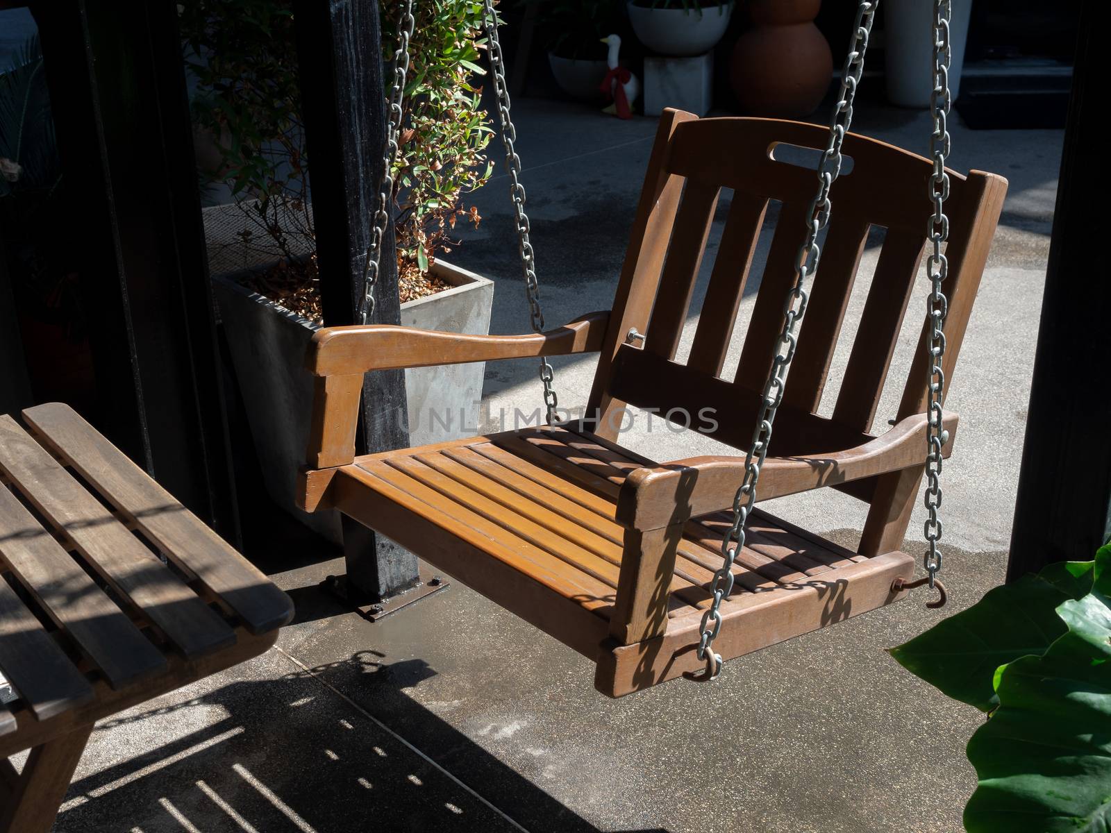 Wooden swing in the backyard. Shady place for relaxation.