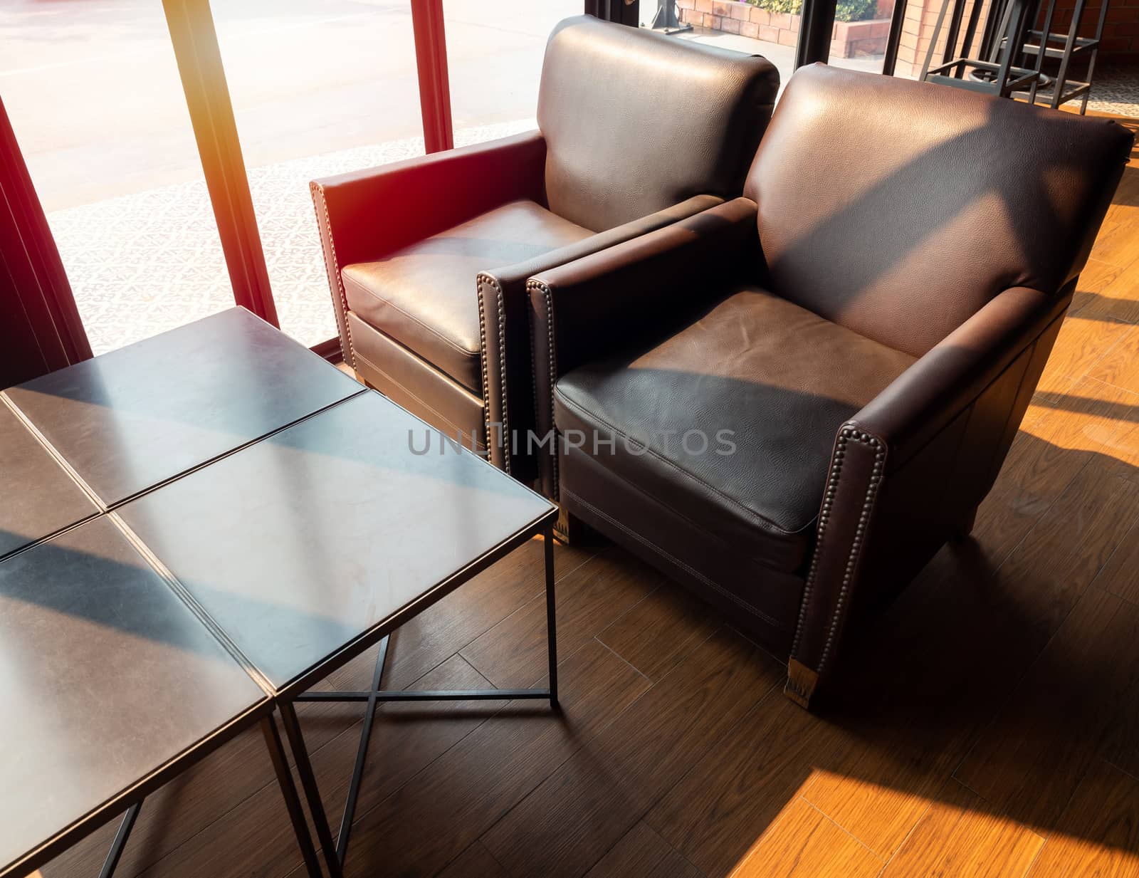 Brown leather sofa with wooden table on wooden floor near glass  by tete_escape