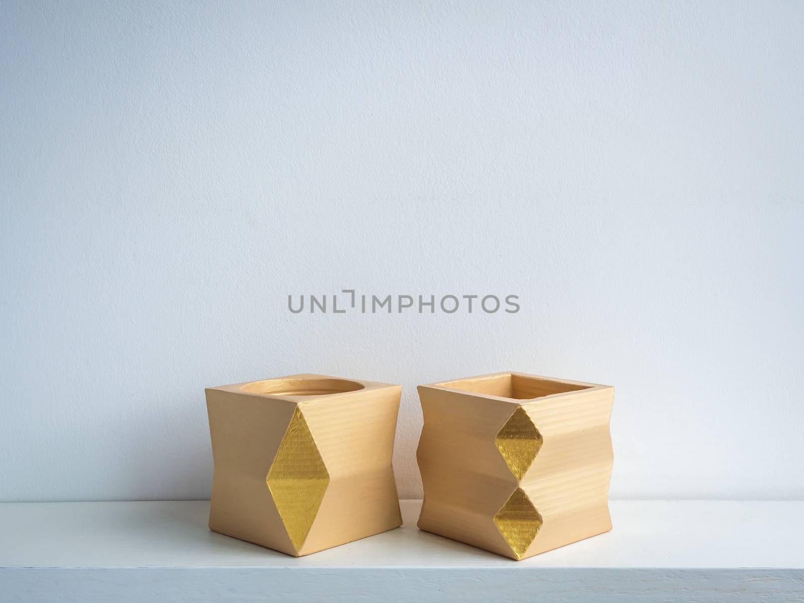 Cactus pot. Concrete pot. Two empty yellow modern geometric concrete planters on white wooden shelf isolated on white background.