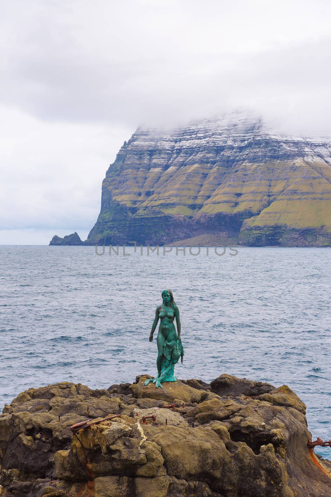 Mikladalur, Faroe Islands, Denmark - May 27, 2019 : Statue of Selkie or Seal Wife in Mikladalur on the island of Kalsoy. Selkies are mythological creatures in Irish, Scottish, and Faroese folklore.