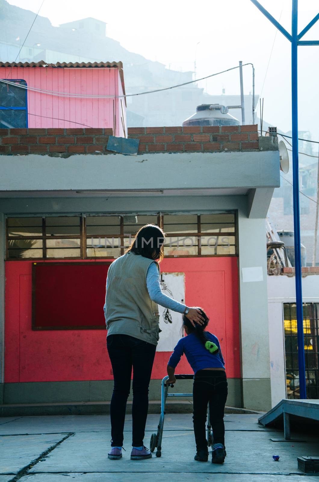 Woman helping disabled girl in a school