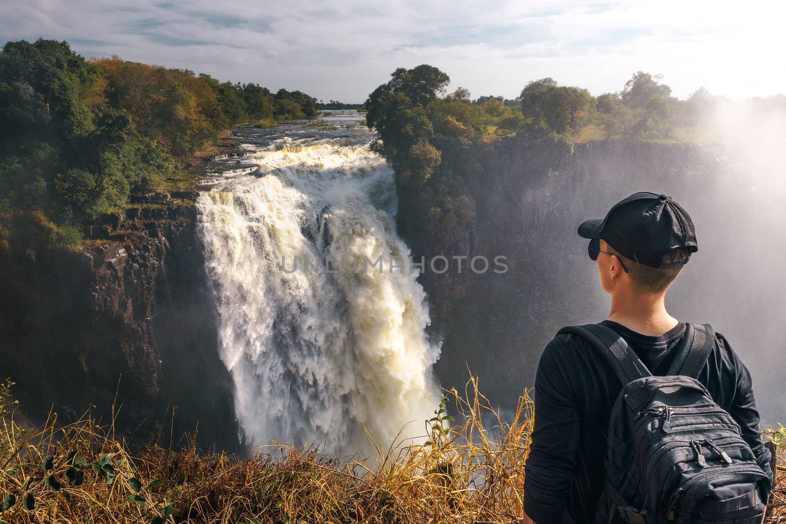 Tourist looks at the Victoria Falls on Zambezi River in Zimbabwe by nickfox