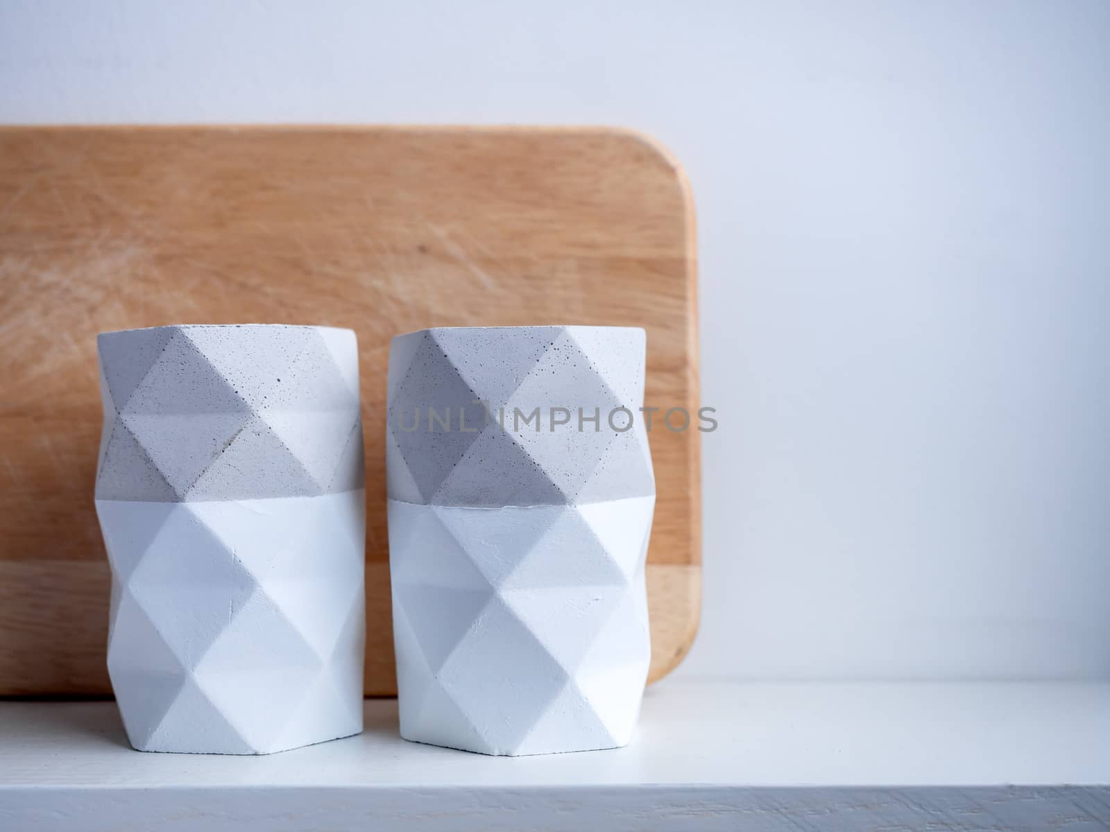 Cactus pot. Concrete pot. Two empty concrete planters on white wooden shelf isolated on white background with copy space.