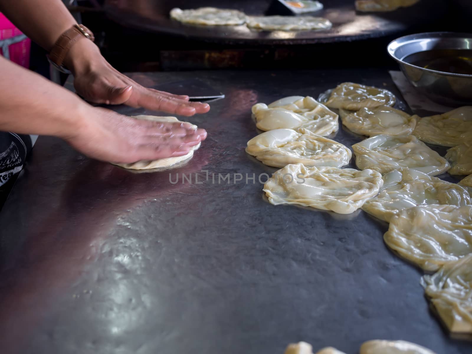 Roti Making, roti thresh flour by roti maker with oil. Indian traditional street food. Hand making roti.
