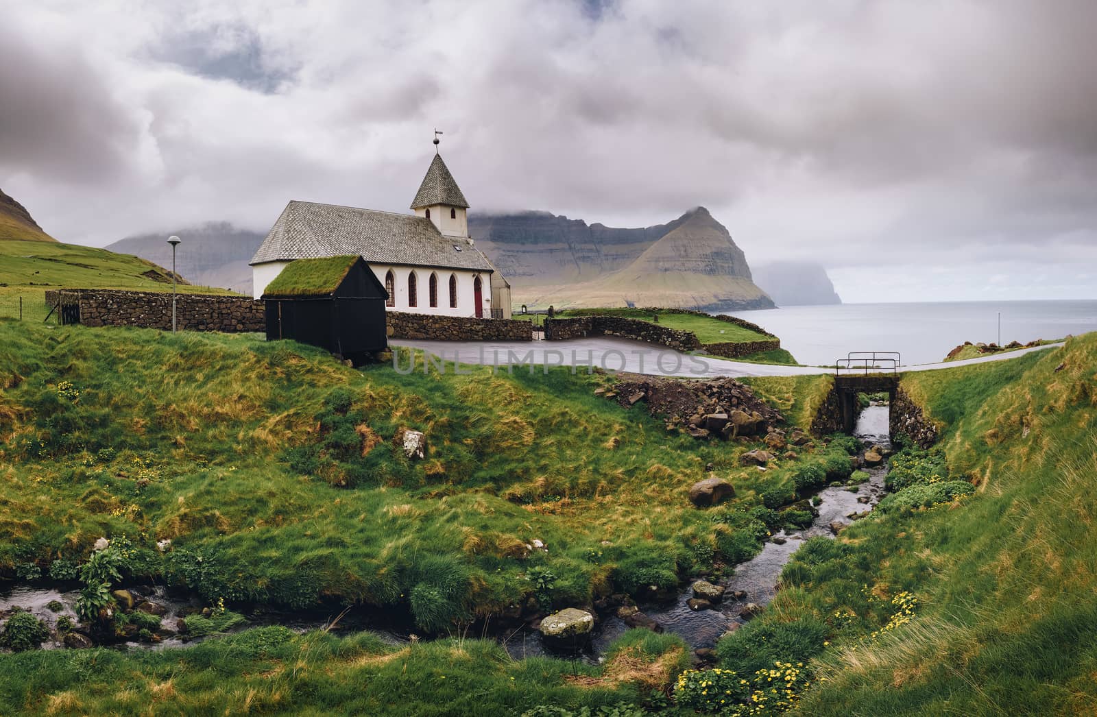 Small village church on the sea shore in Vidareidi, Faroe Islands, Denmark by nickfox