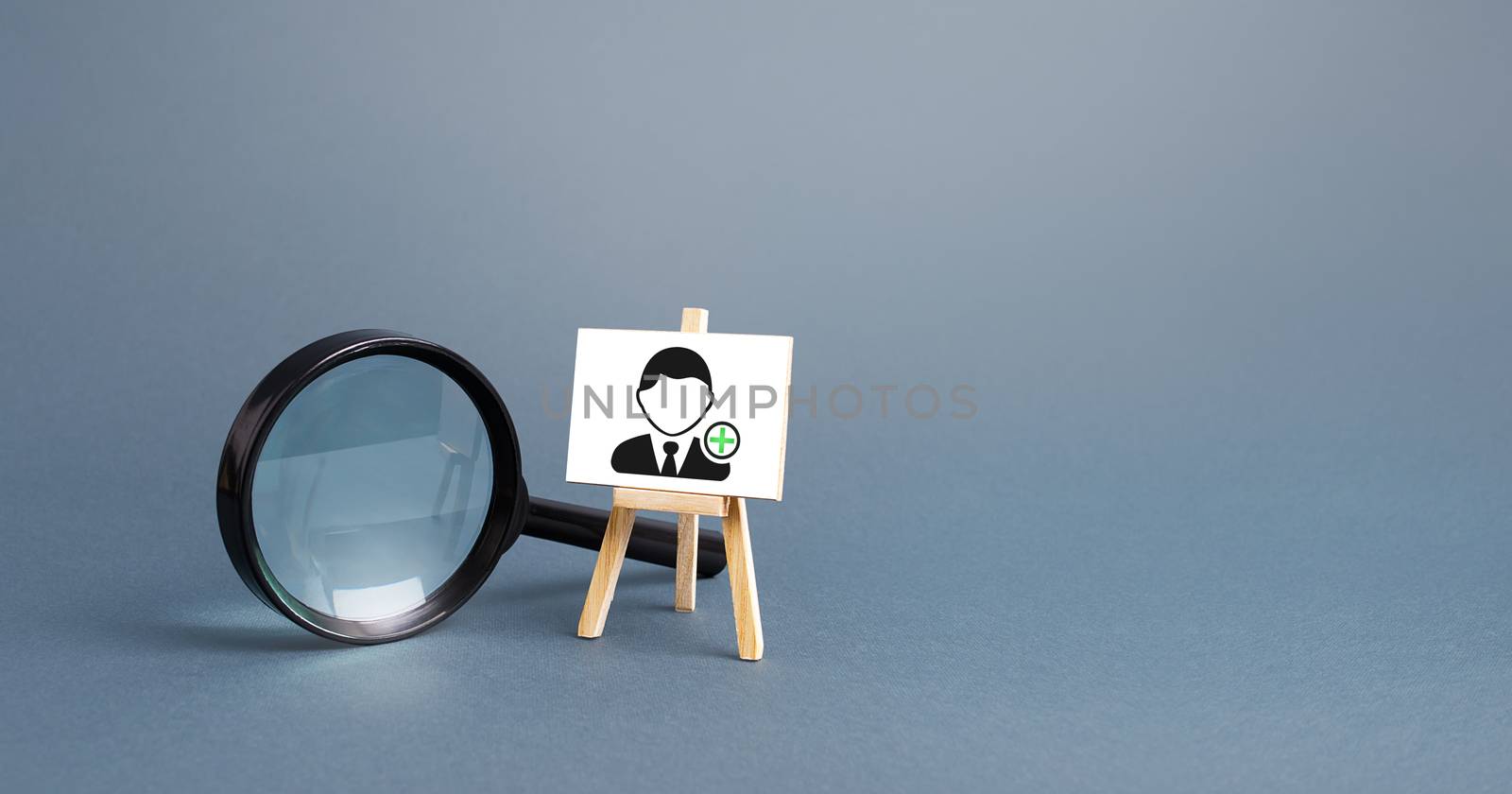 Magnifying glass and an easel with a new hired employee. Recruiting and HR management. Hiring new workers, staffing. Headhunters and Human Resources. Search for skilled specialists and professionals. by iLixe48