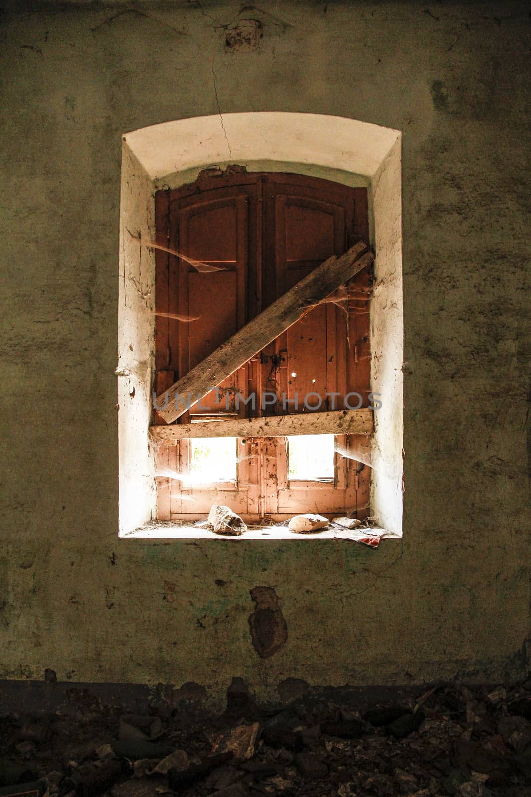 Window of an abandoned house taken from inside; the light illumi by robbyfontanesi