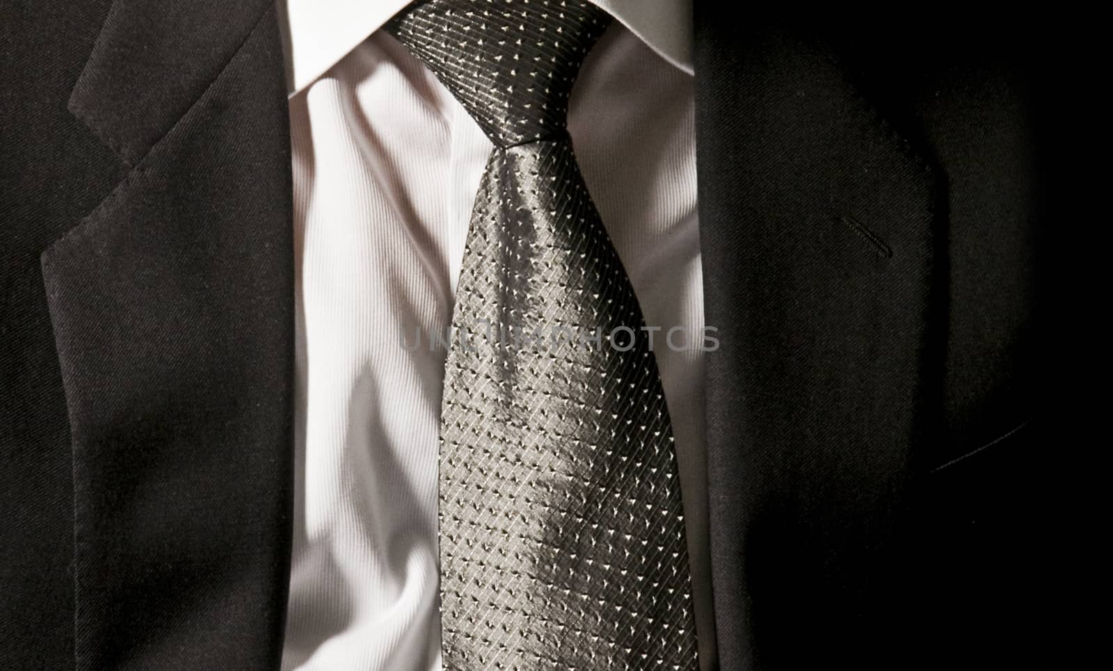 The boss's tie. The businessman is wearing his dark gray jacket on the white shirt with an elegant gray tie