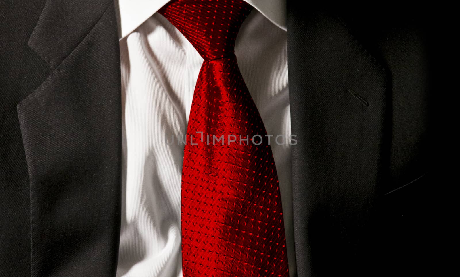 The boss's tie. The businessman is wearing his dark gray jacket on the white shirt with a gaudy red tie
