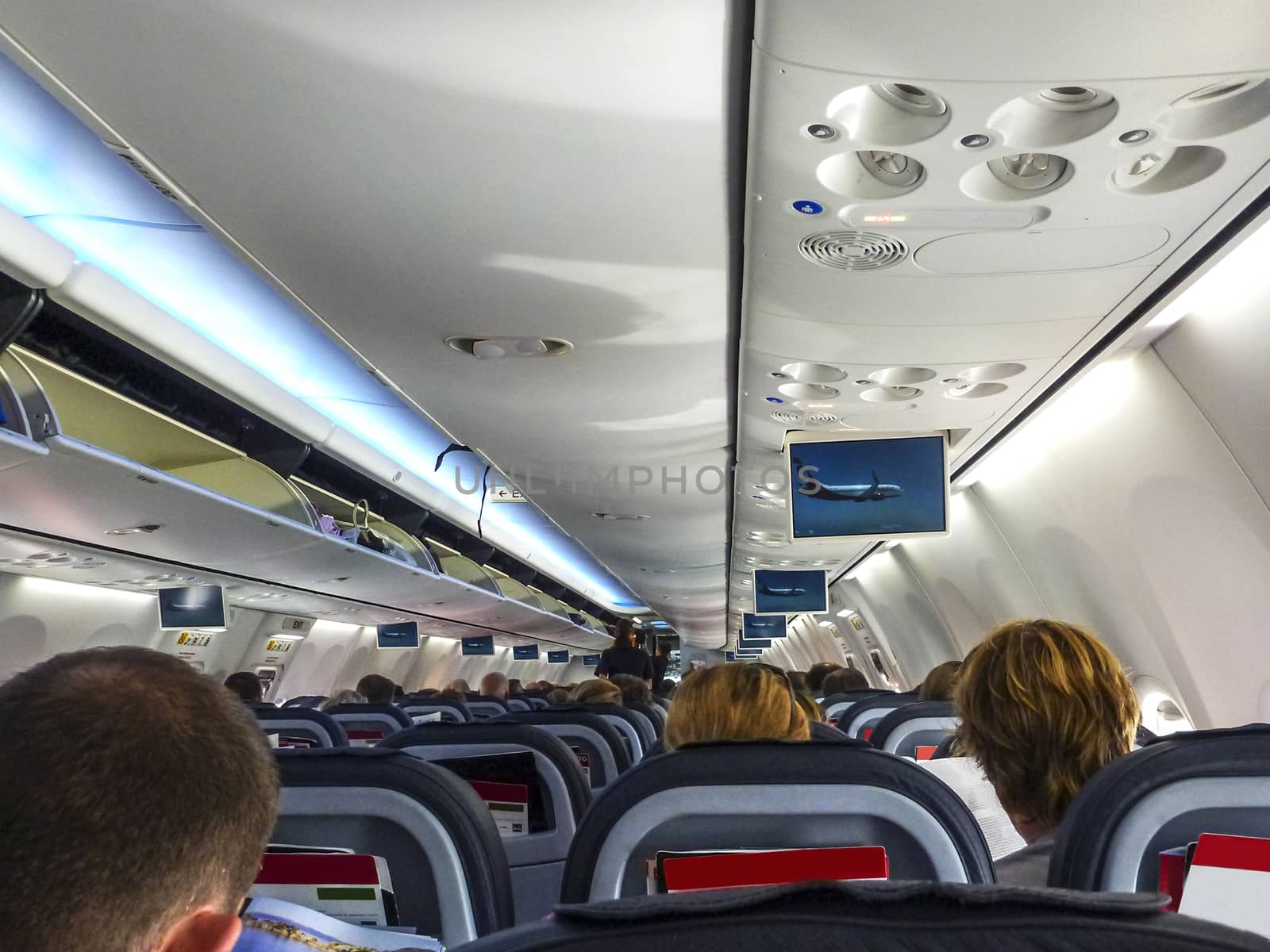 Air Berlin Boeing 737-800 interior taking off with passengers seated and perspective view of the seats and overheads. All trademarks are deleted.
