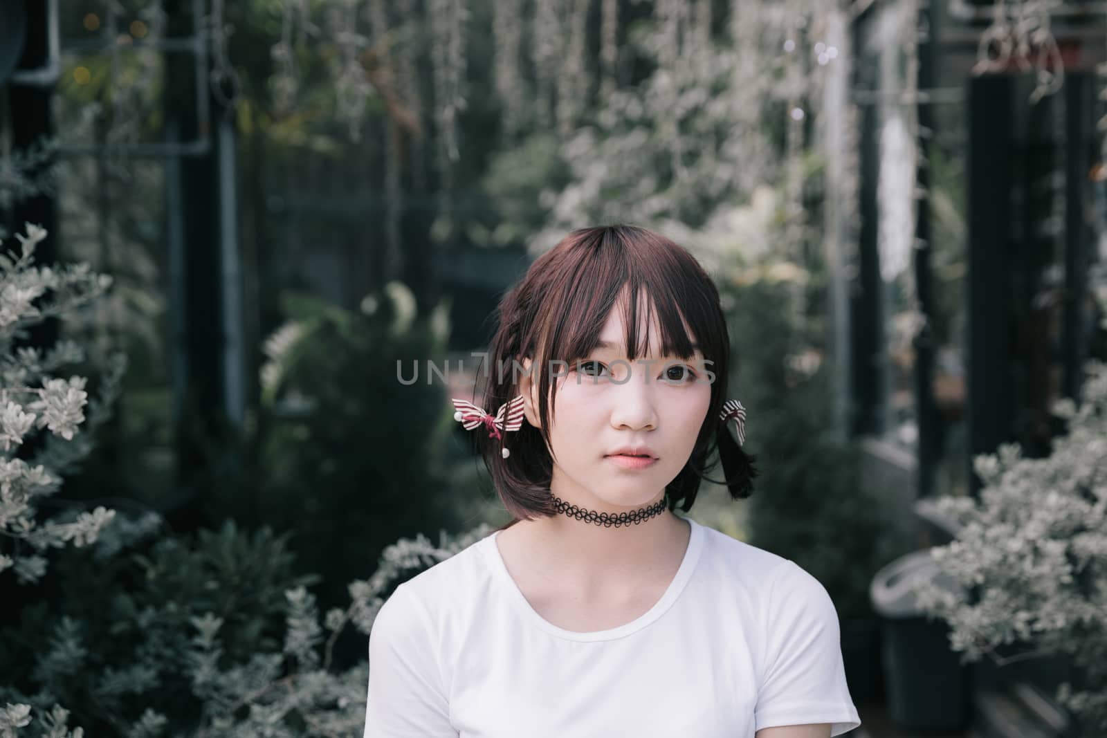 portrait of asian girl with white shirt and skirt looking in outdoor nature vintage film style