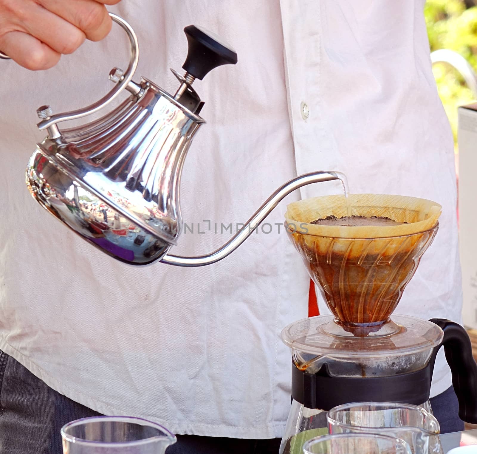 An outdoor food stall prepares drip coffee