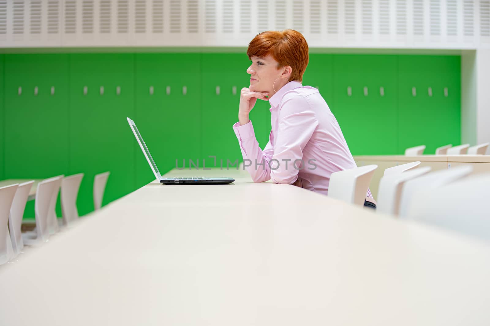 Young beautiful woman on a university lecture working on a white laptop
