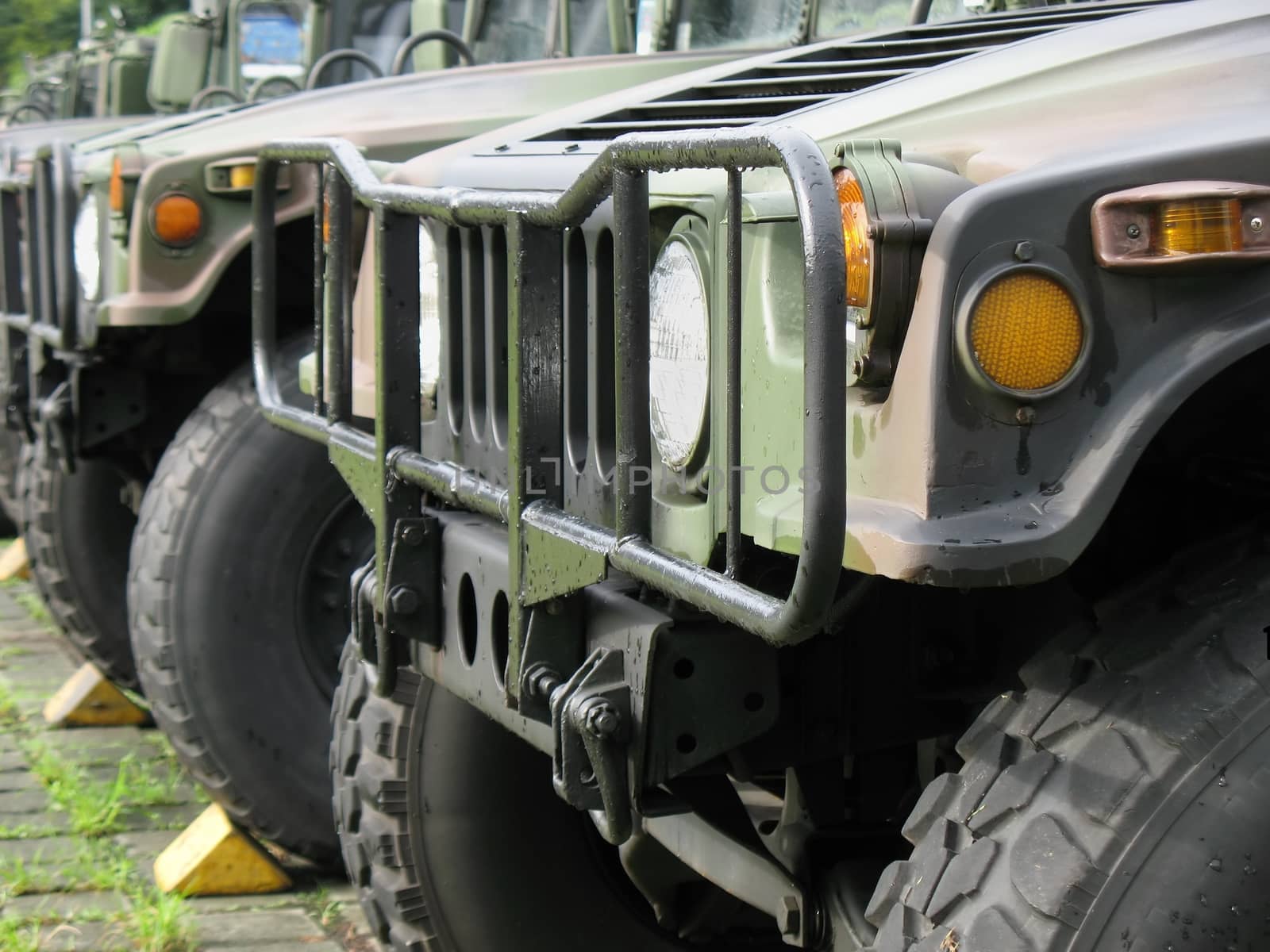 Heavy military vehicles are parked in a line