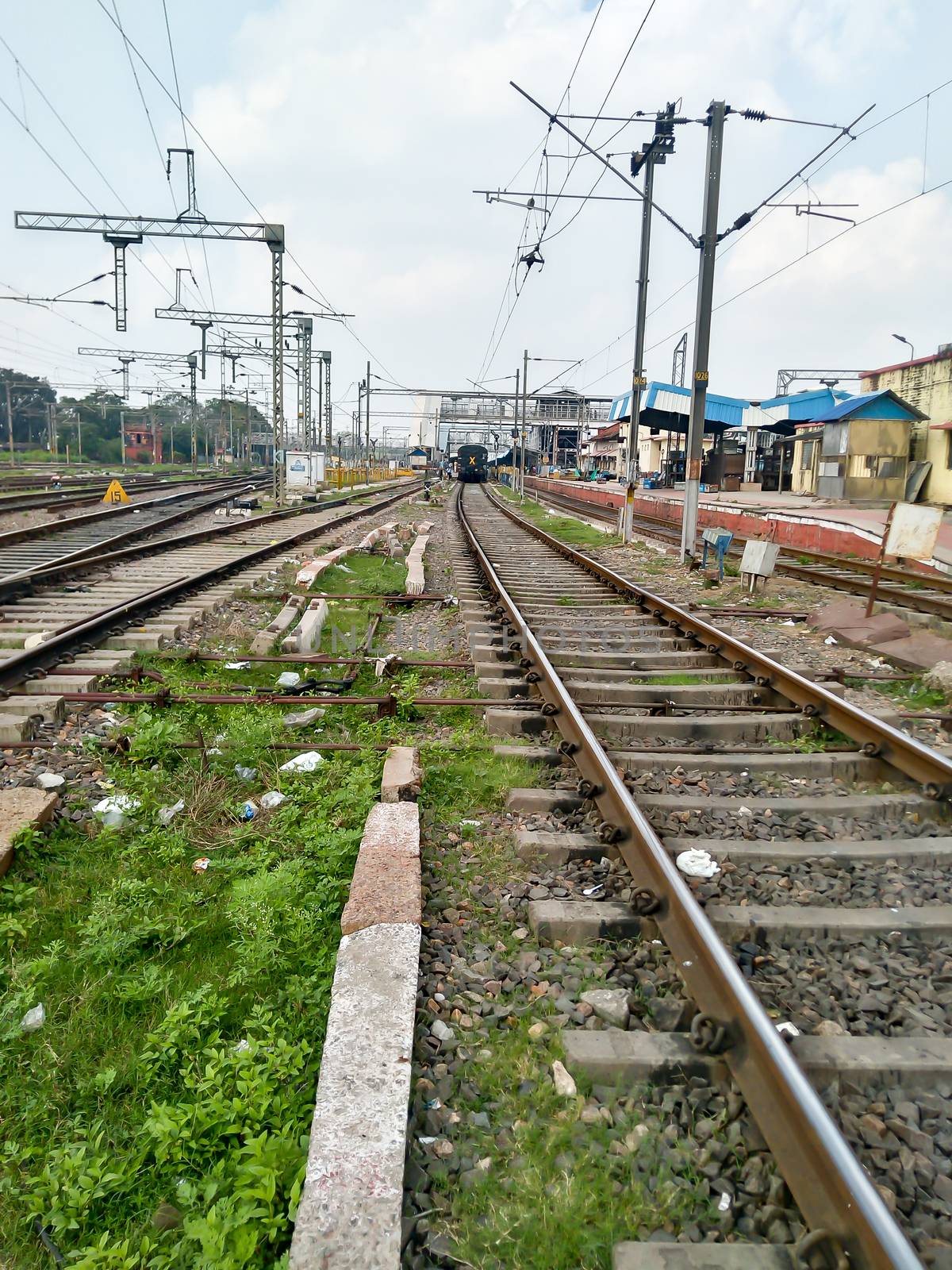 Close Up of Indian Railway Tracks low angel view from a rails sleepers near railway station platform during day time in Howrah Station car shed area. Kolkata India South Asia Pacific March 18, 2020