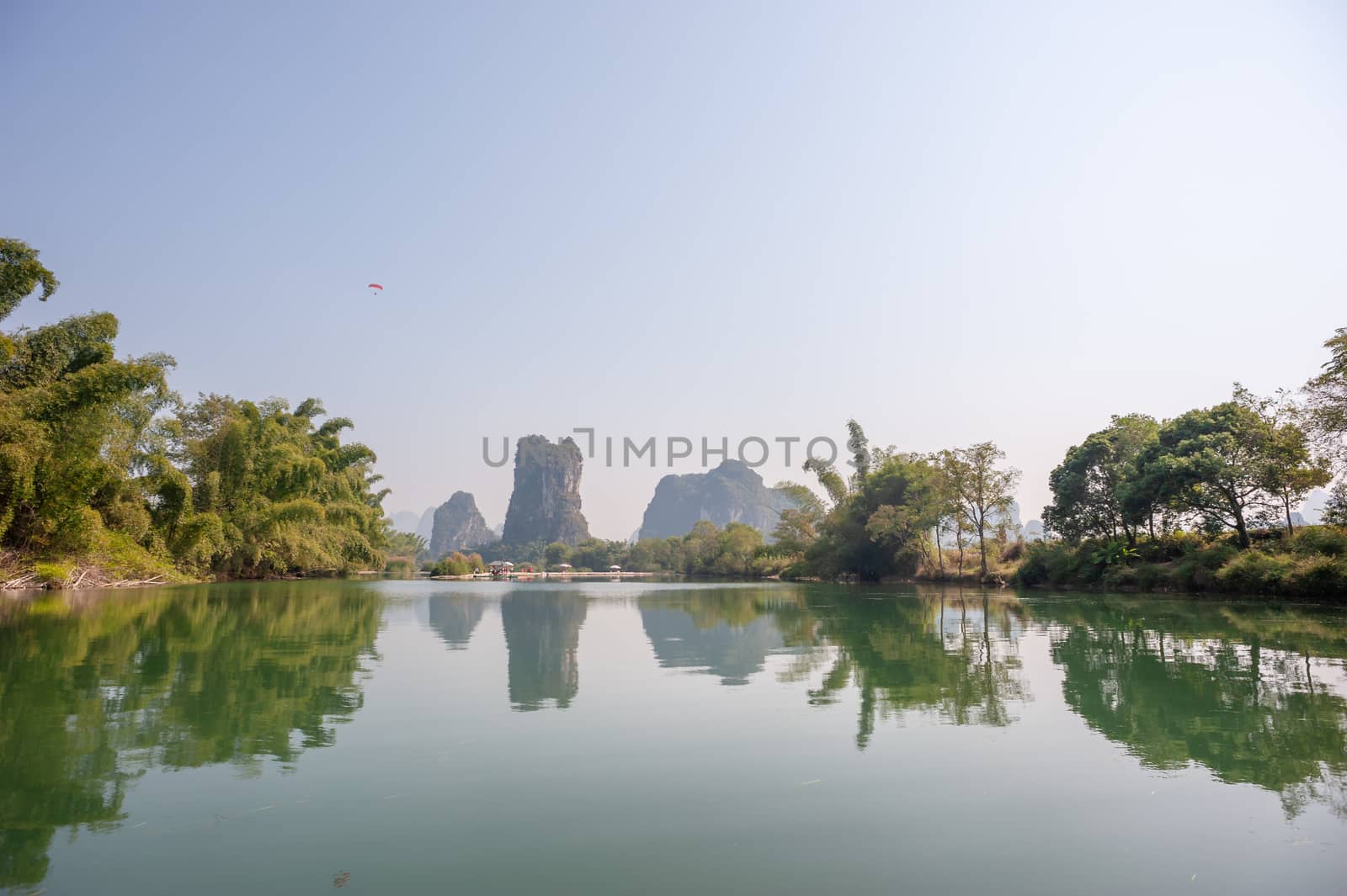 Lake with limestone karst hills foggy landscape reflecting in the river in Yangshuo, Guangxi province, China