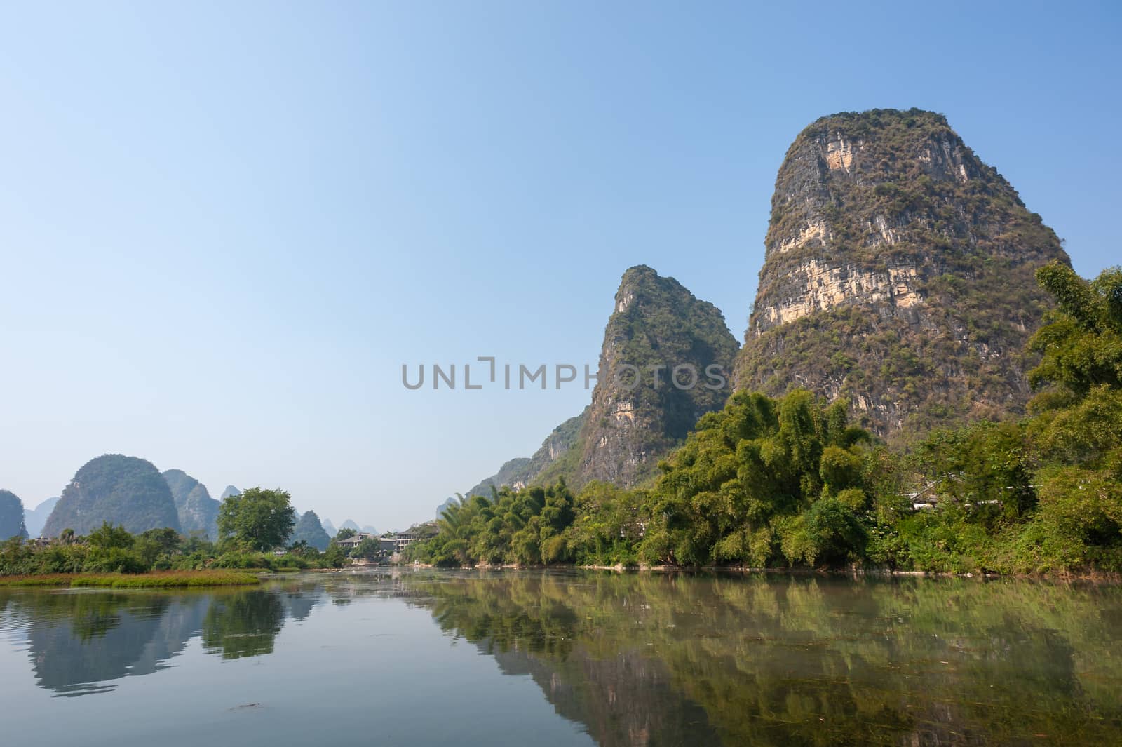 Lake with limestone karst hills foggy landscape reflecting in the river in Yangshuo, Guangxi province, China