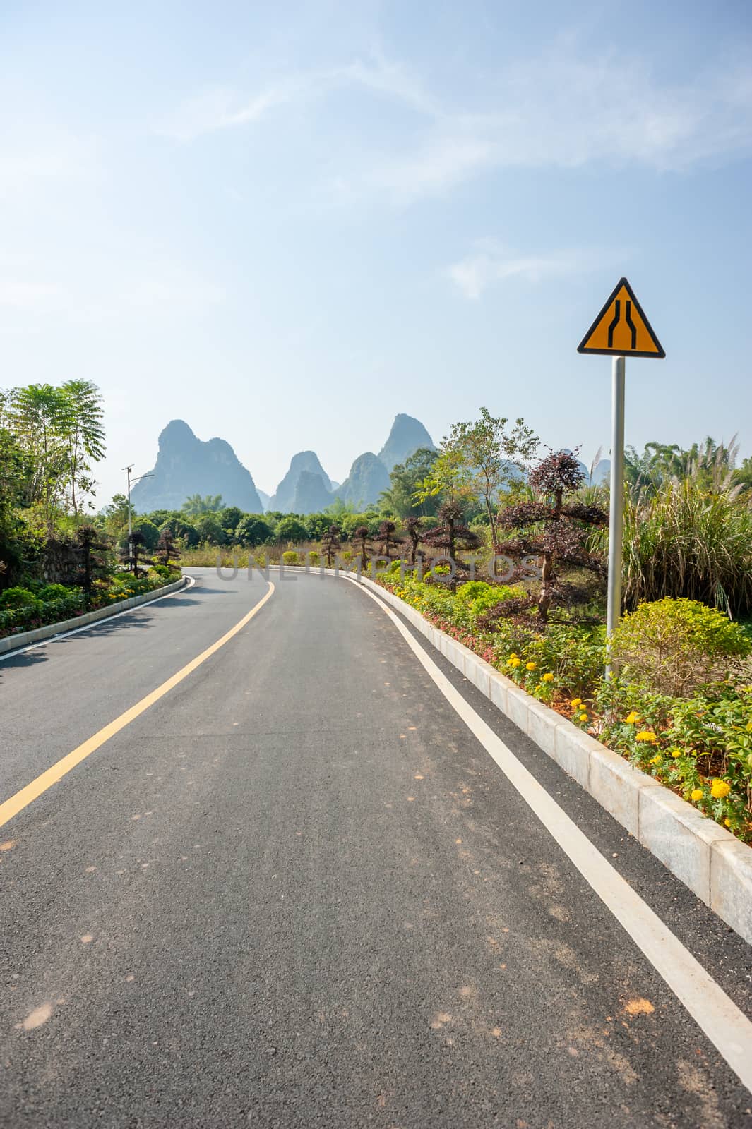 Empty road with karst hills in the background in Yangshuo, Guilin, Guangxi province, China
