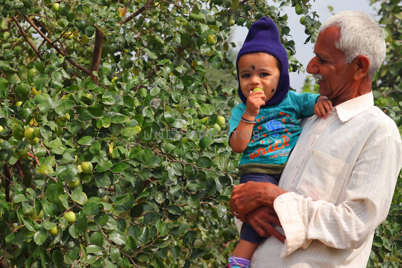March 6, 2020. happy child and mid age grand father standing in the garden rajasthan, india